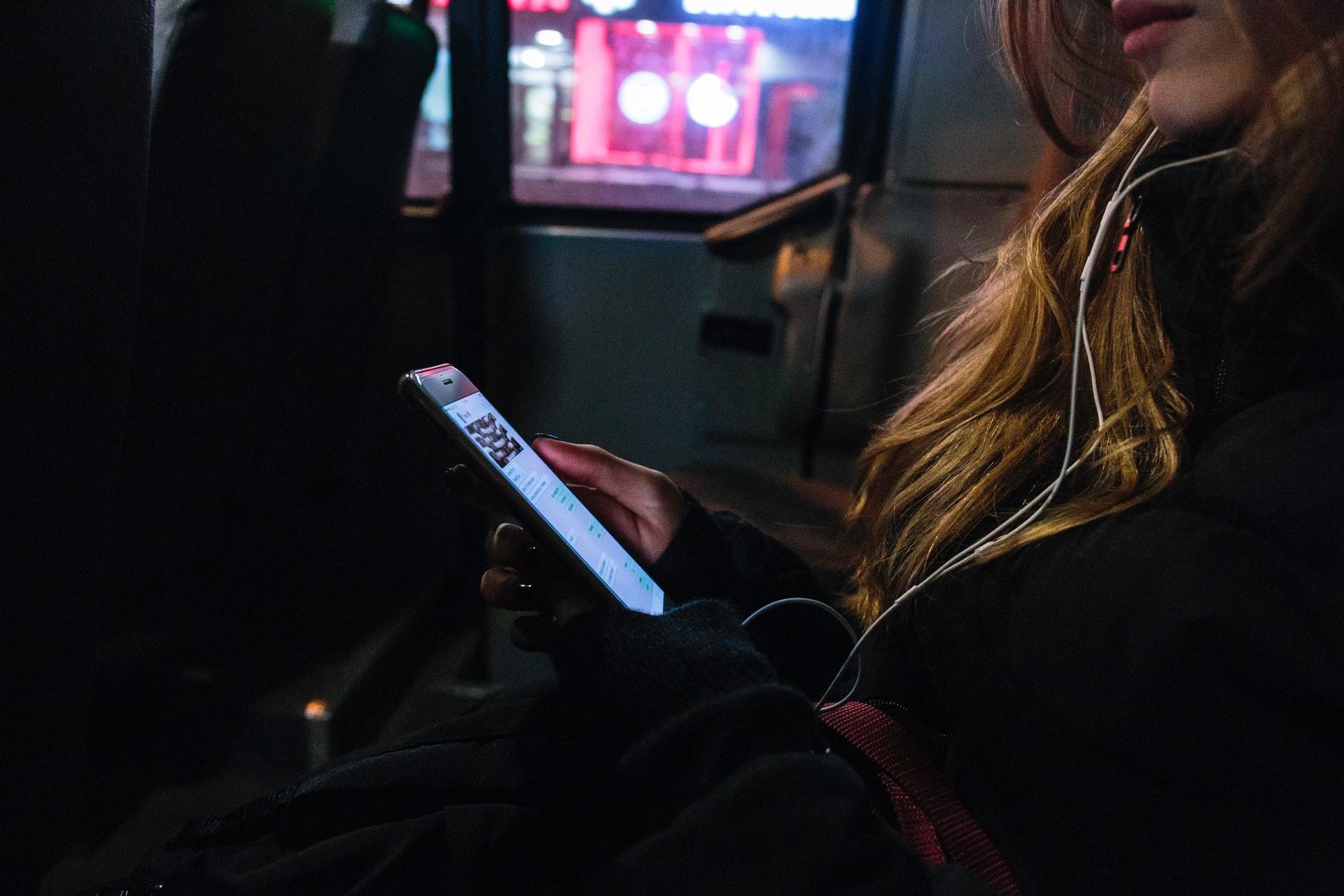 Kvinne på buss med headset.
