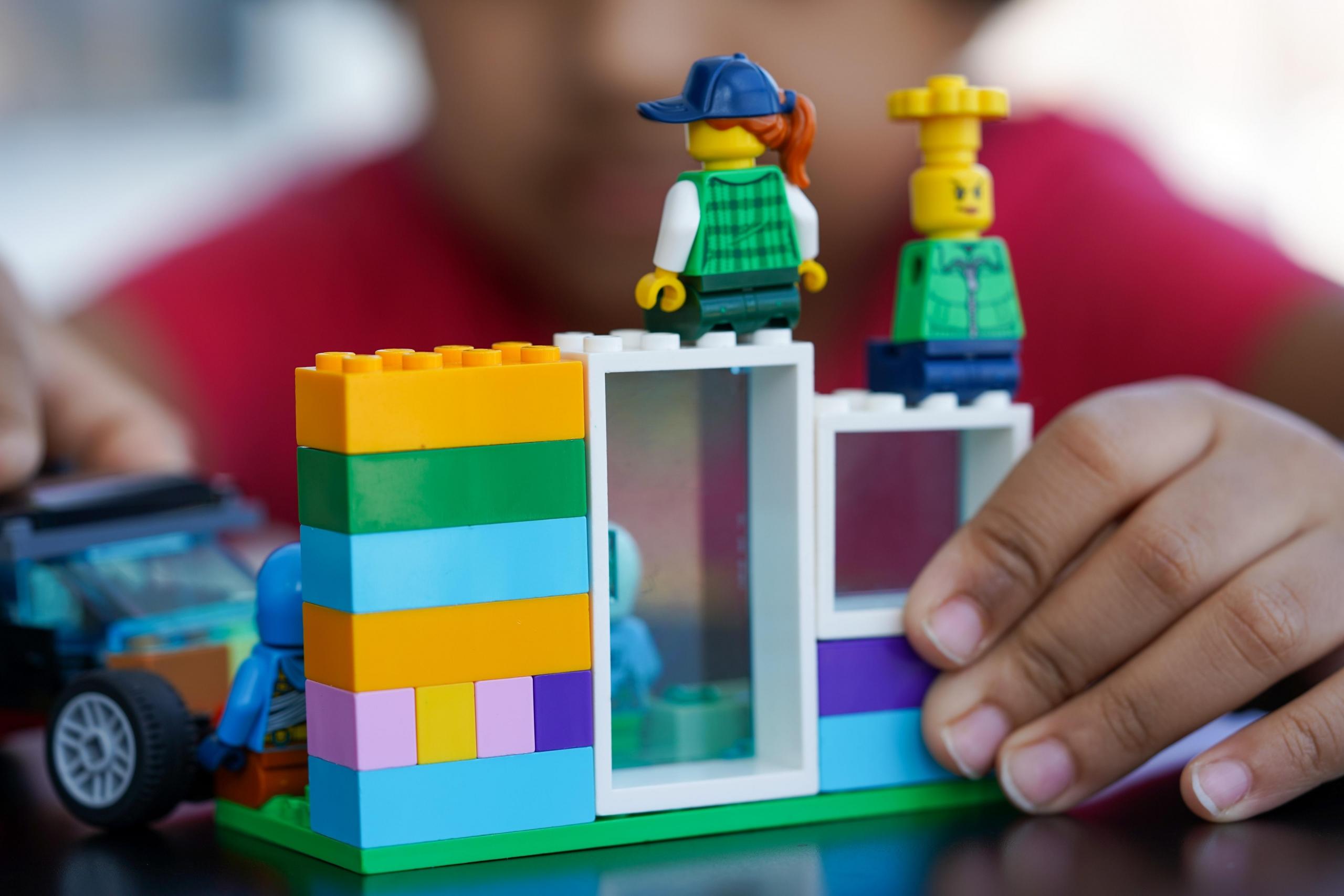 barn leker med lego, en vegg med en dør og et vindu er bygget