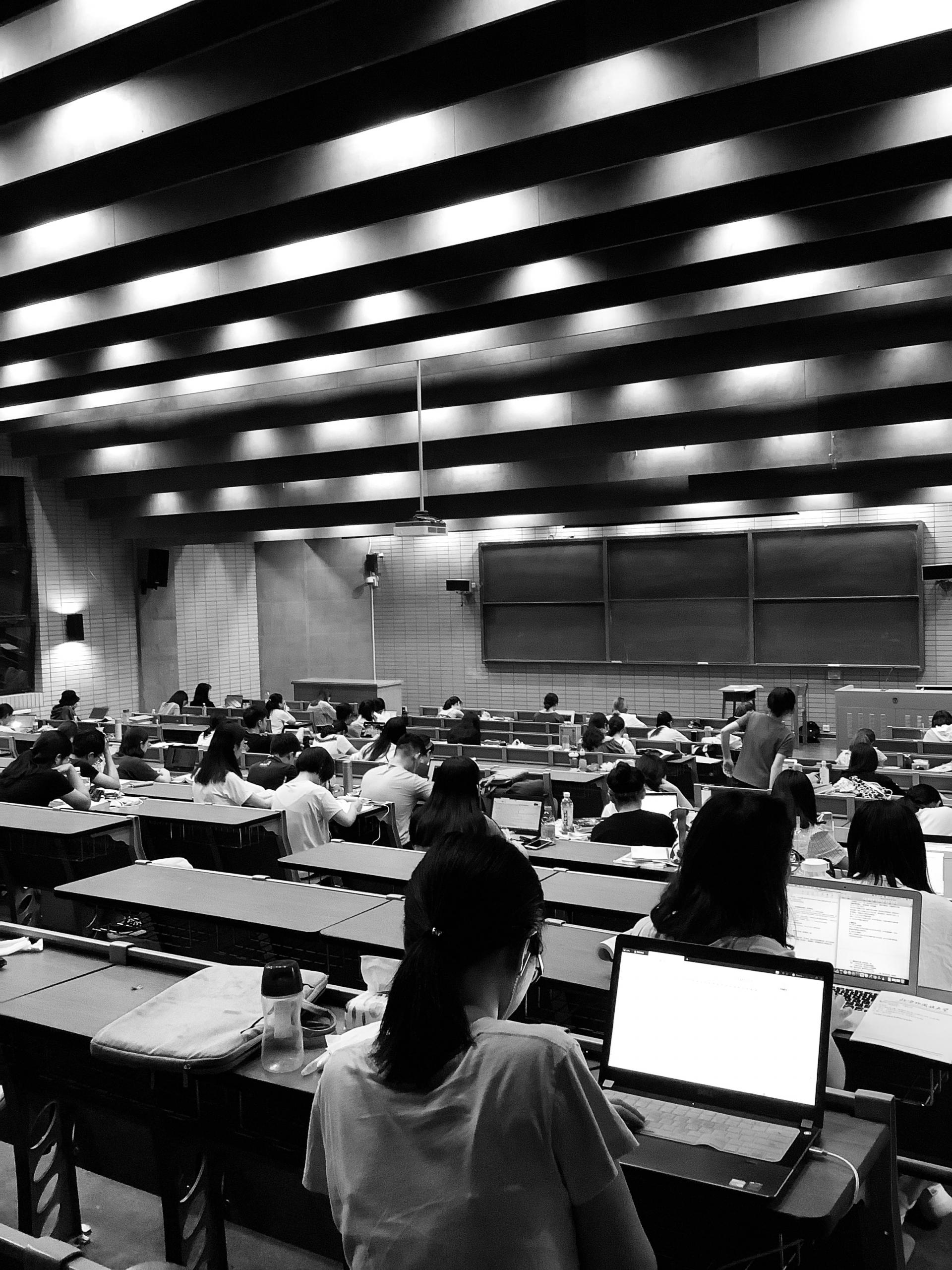 bilde av studenter i et auditorium, kameraet rettet mot tavlen