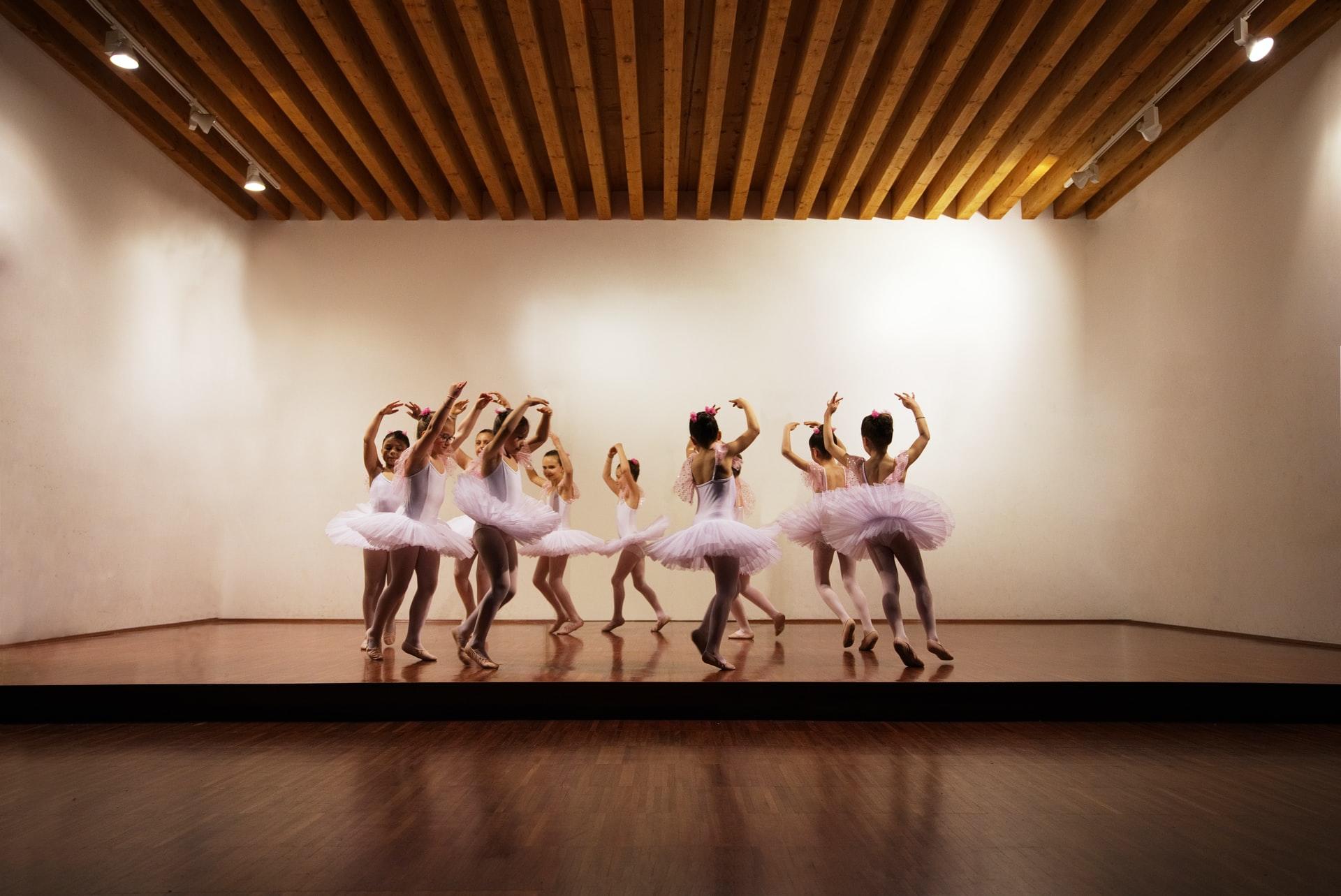 Jenter som danser ballett i tutu, på en scene