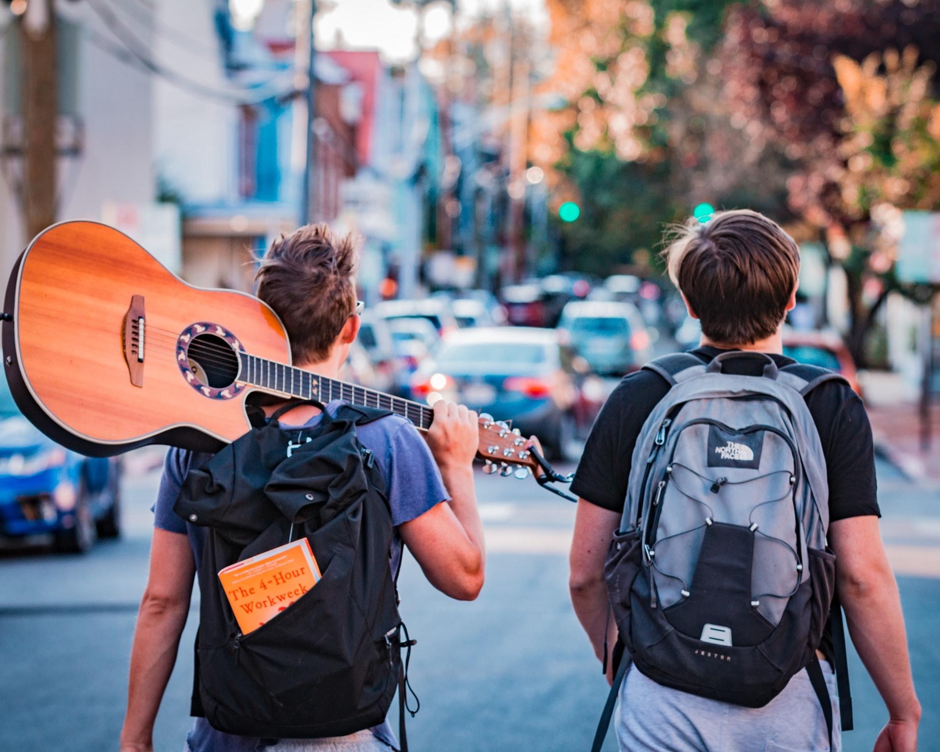 Barn som er på vei hjem fra skolen med gitar