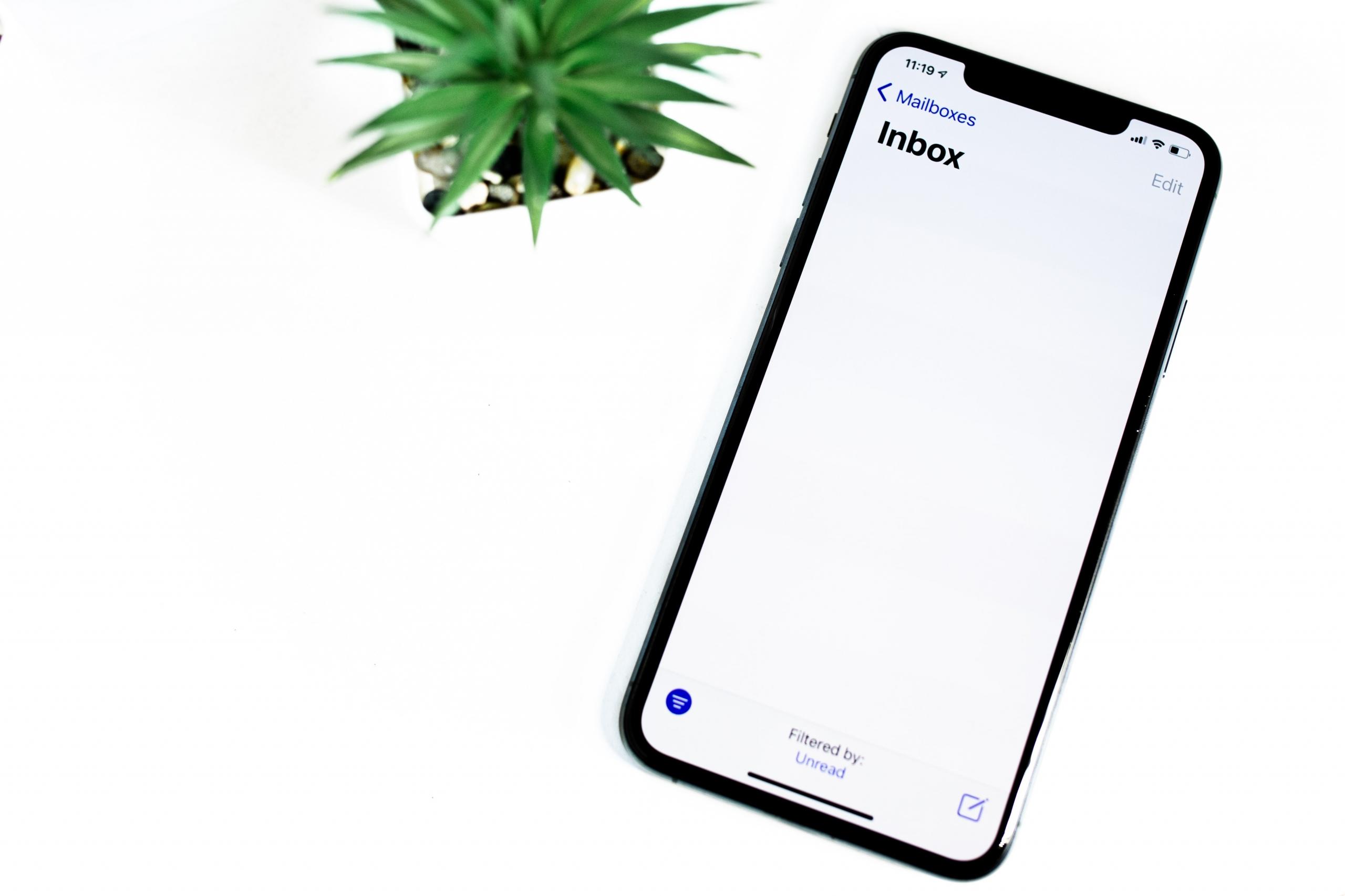 mobil på bord, det står "inbox" på skjermen