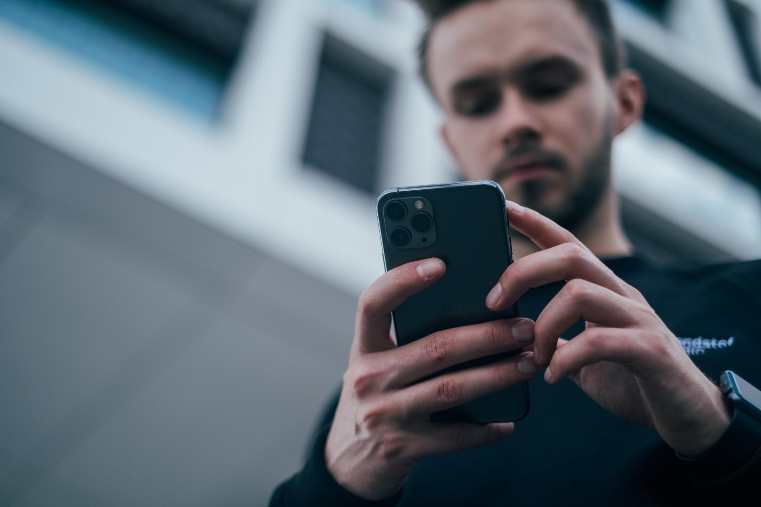 mann ser på mobilen sin