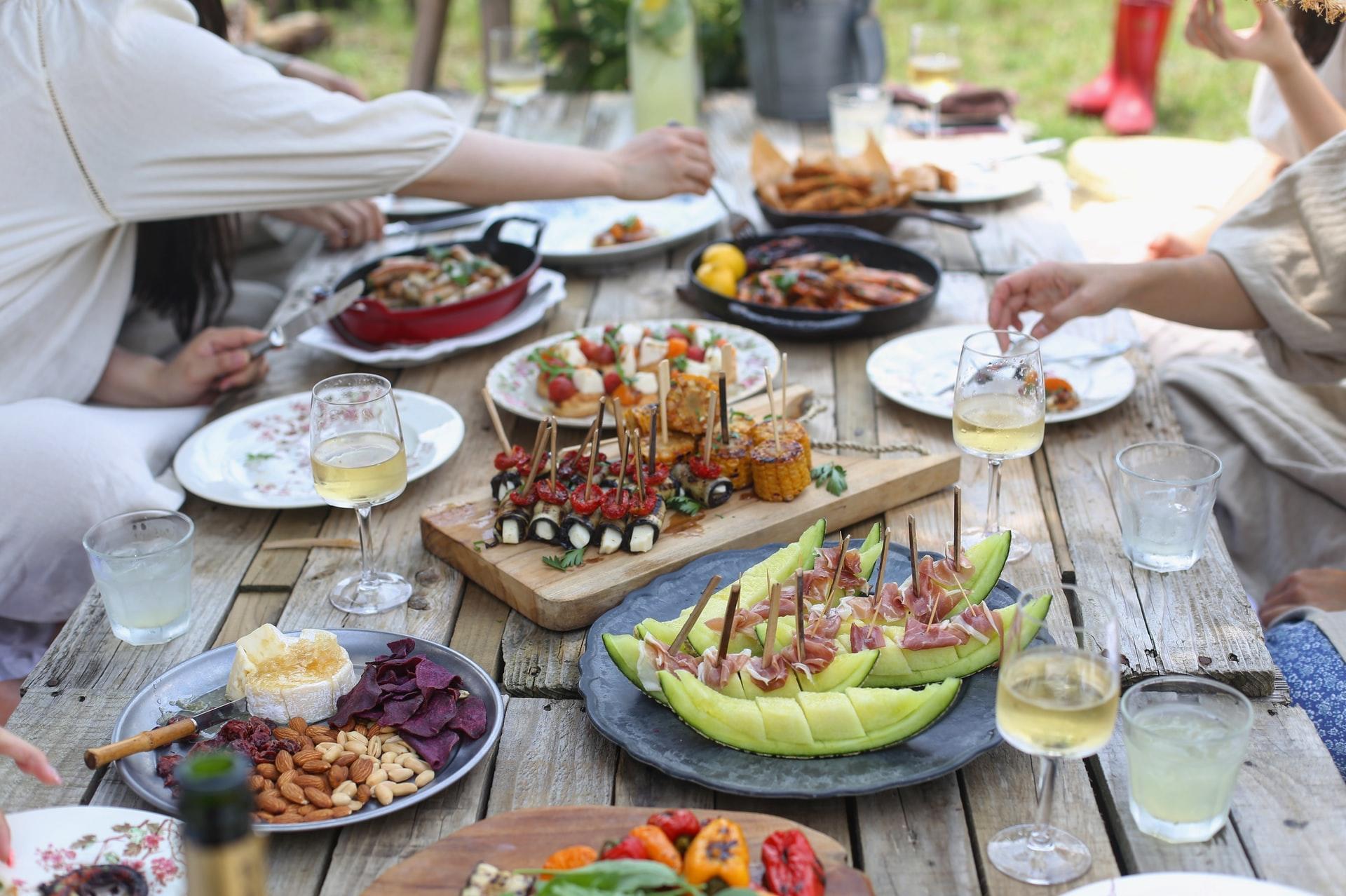 Bord med masse ulike mat og personer som spiser middag