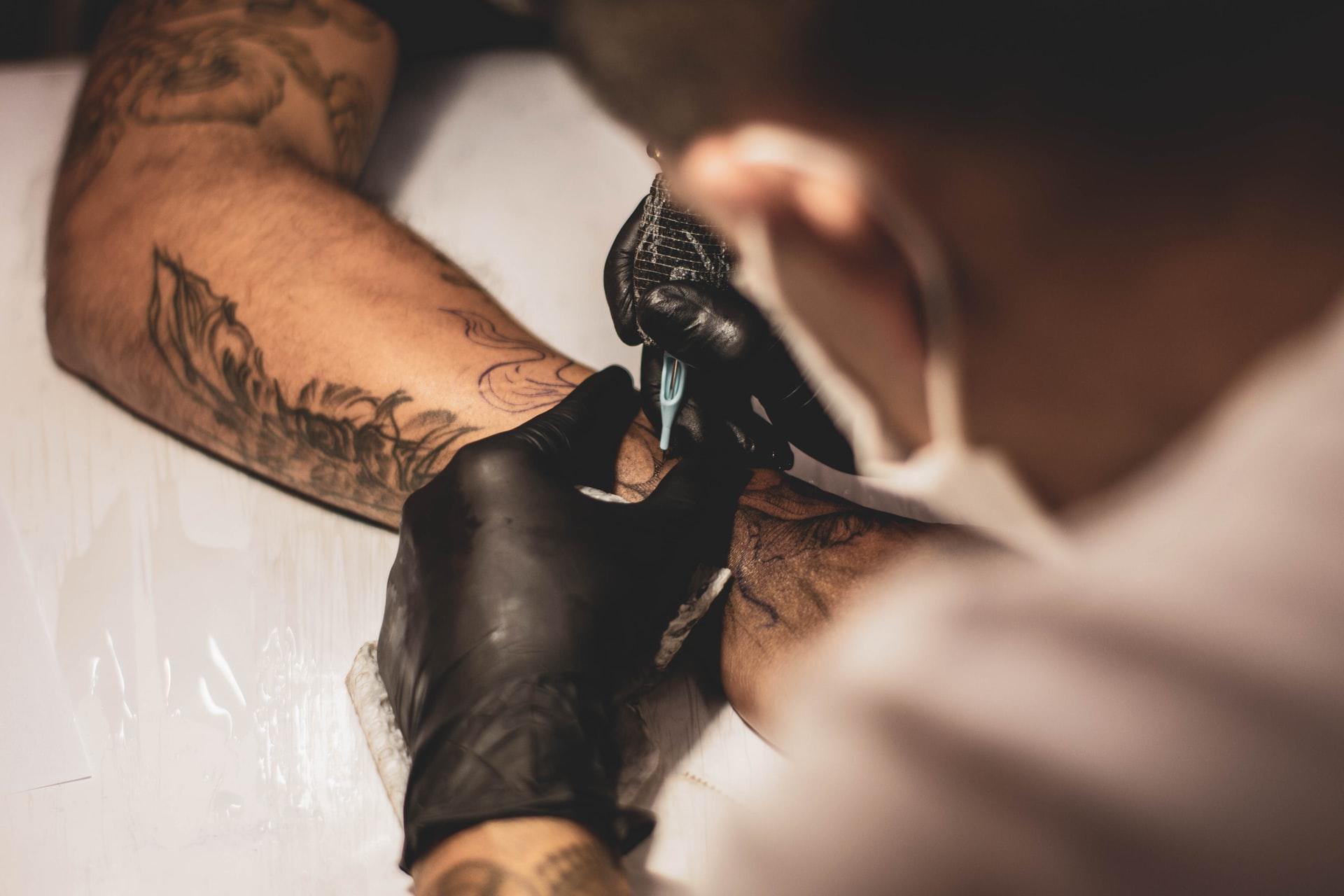 En arm med tatoveringer som blir tatovert