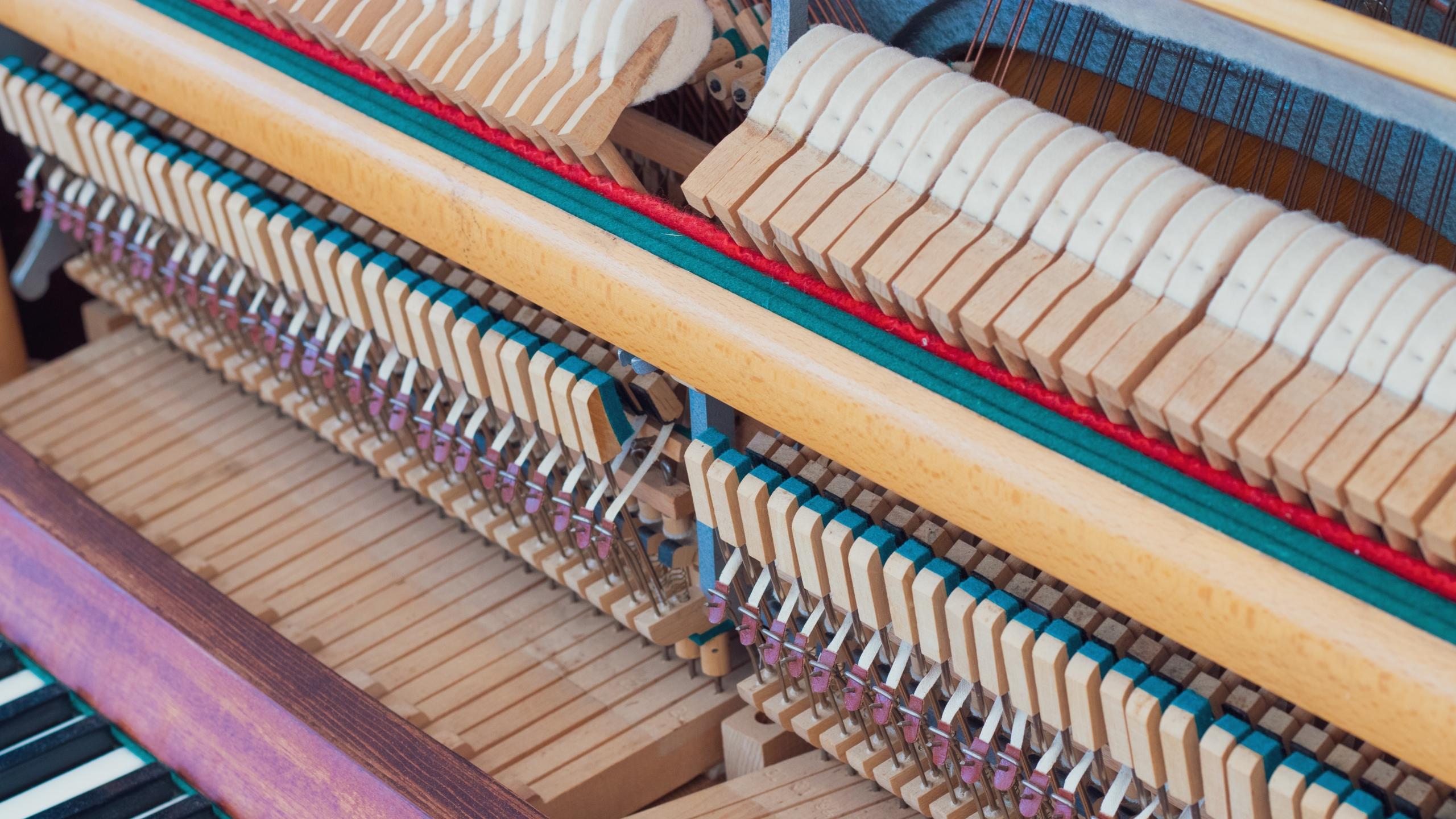 bilde av innsiden av et piano, hammerne med filt er lett synlige