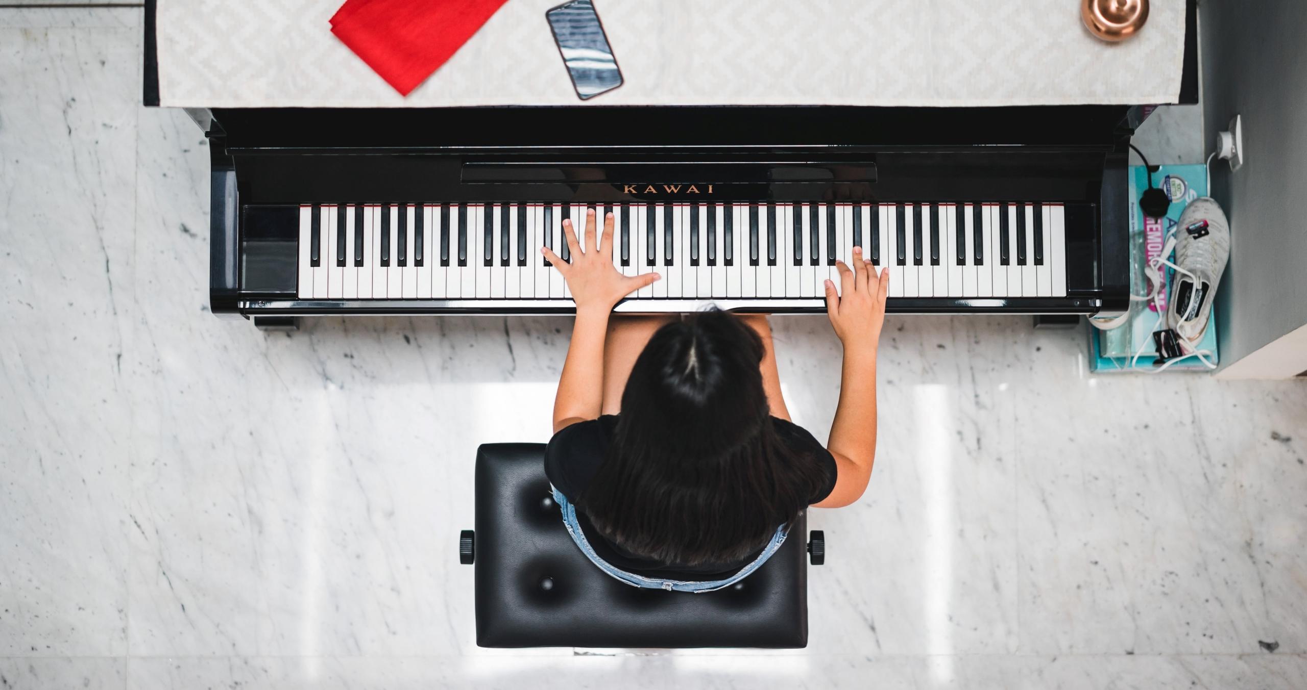 en jente spiller på et piano fra Kawai