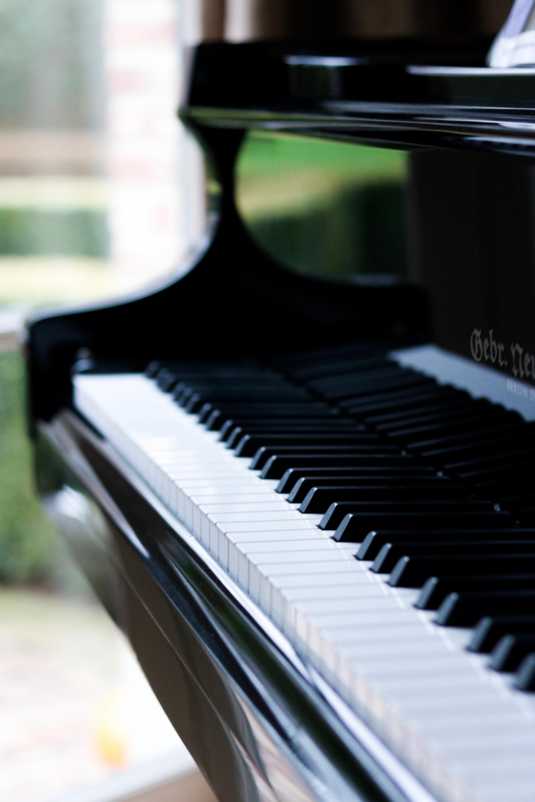 nærbilde langs tangentene på et pent, svart piano