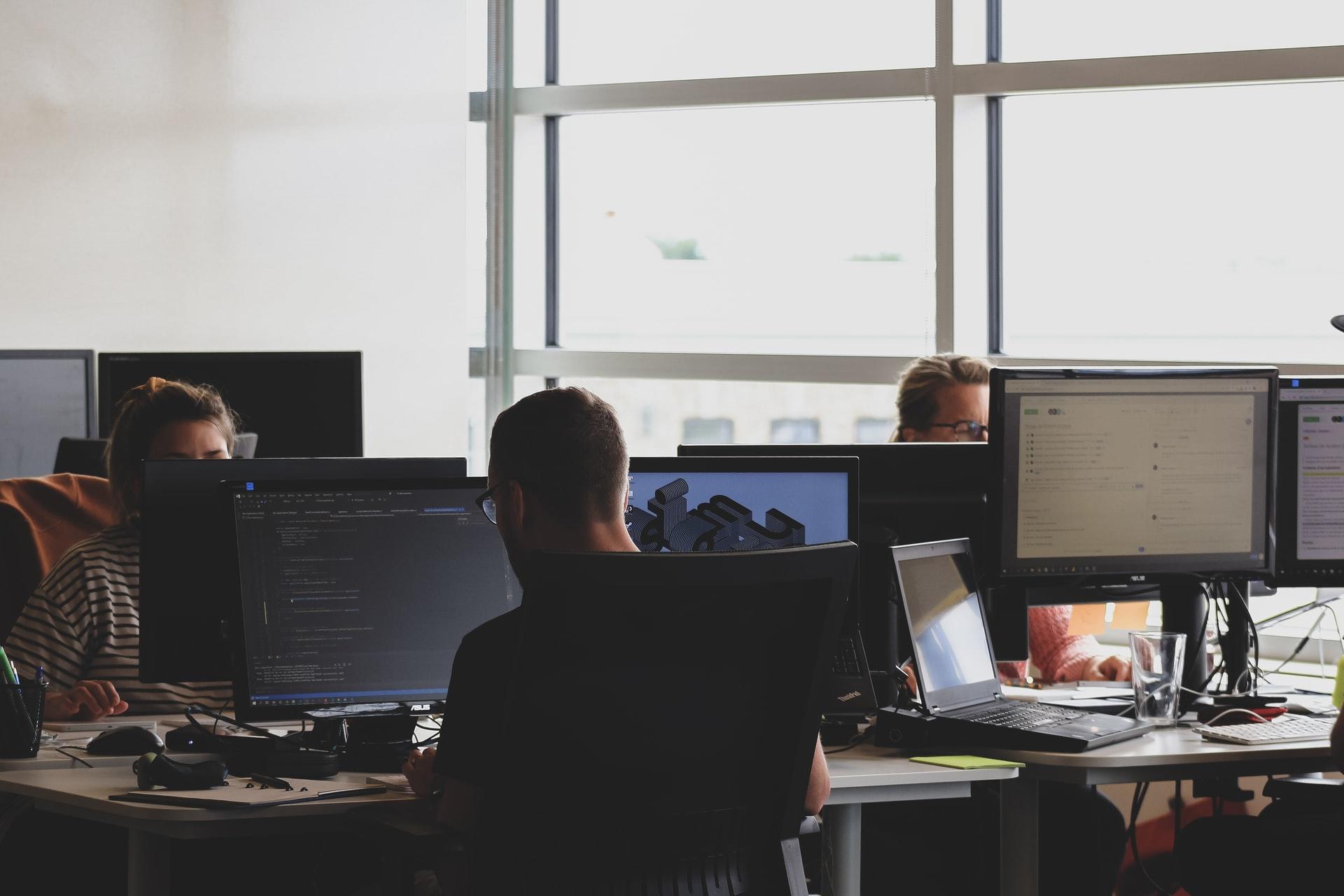 En gruppe med personer som sitter i et kontorlandskap og jobber med Python