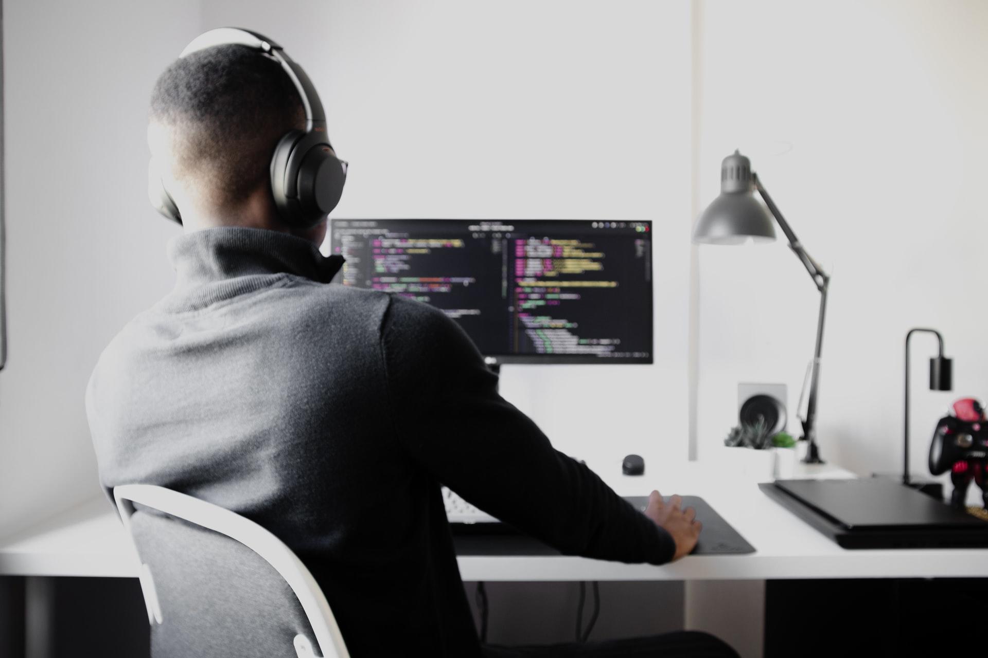 En mann som sitter på en stol på et kontor og jobber med Python