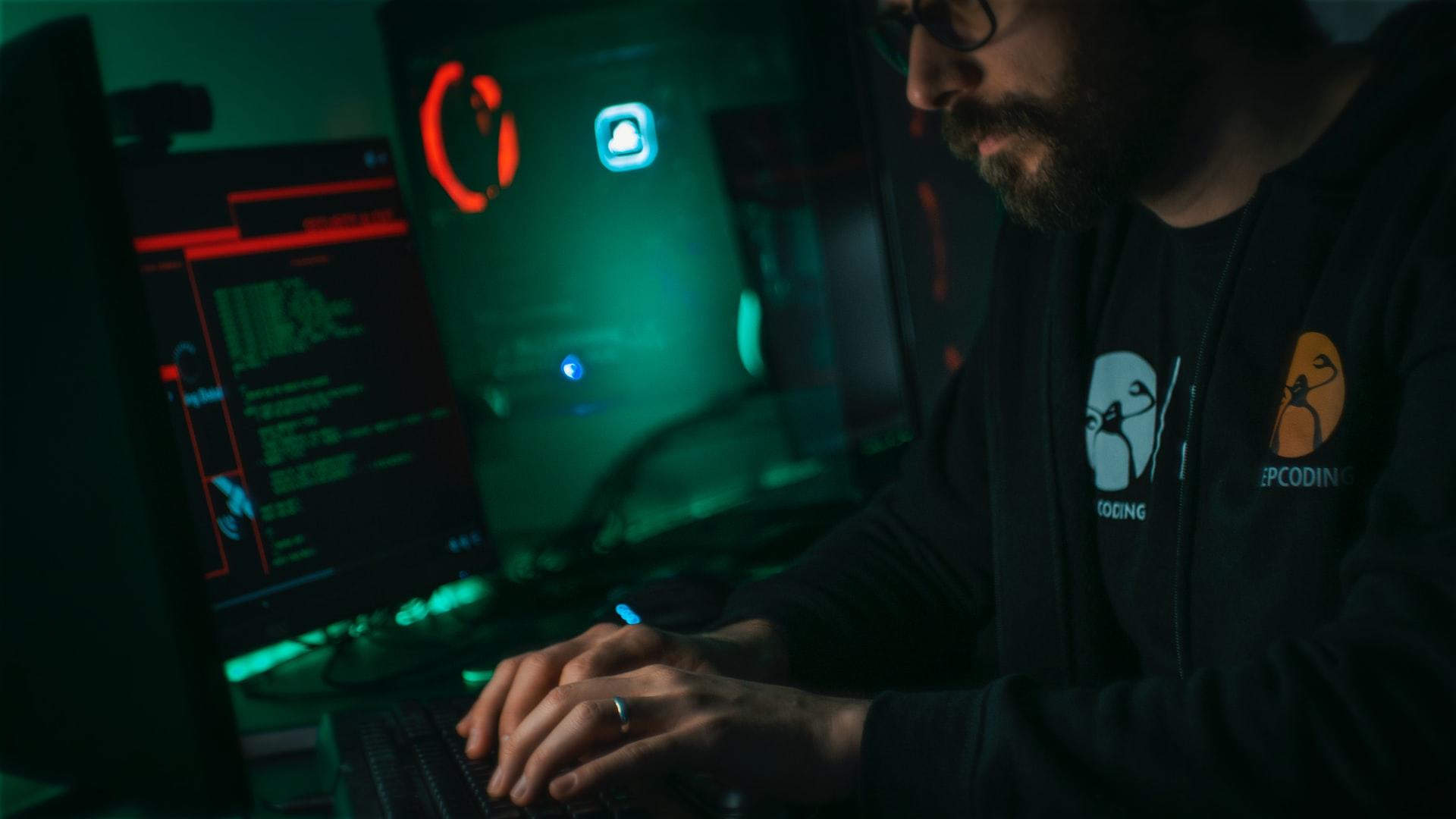 Et mørkt bilde av en person som koder og lærer python på en datamaskin