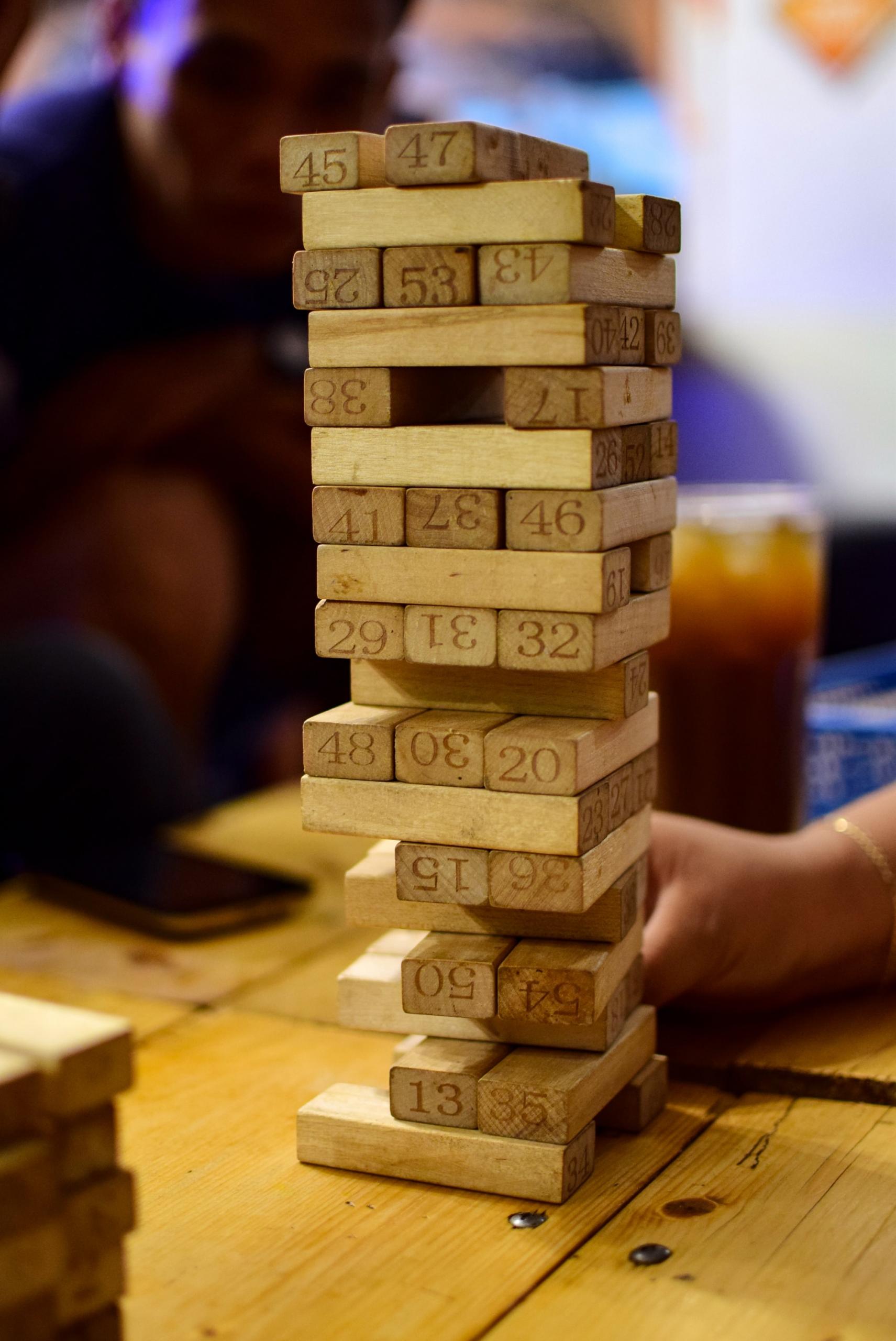 et ustabilt jenga-tårn med mange manglende klosser der hver har en tilhørende fransk glose
