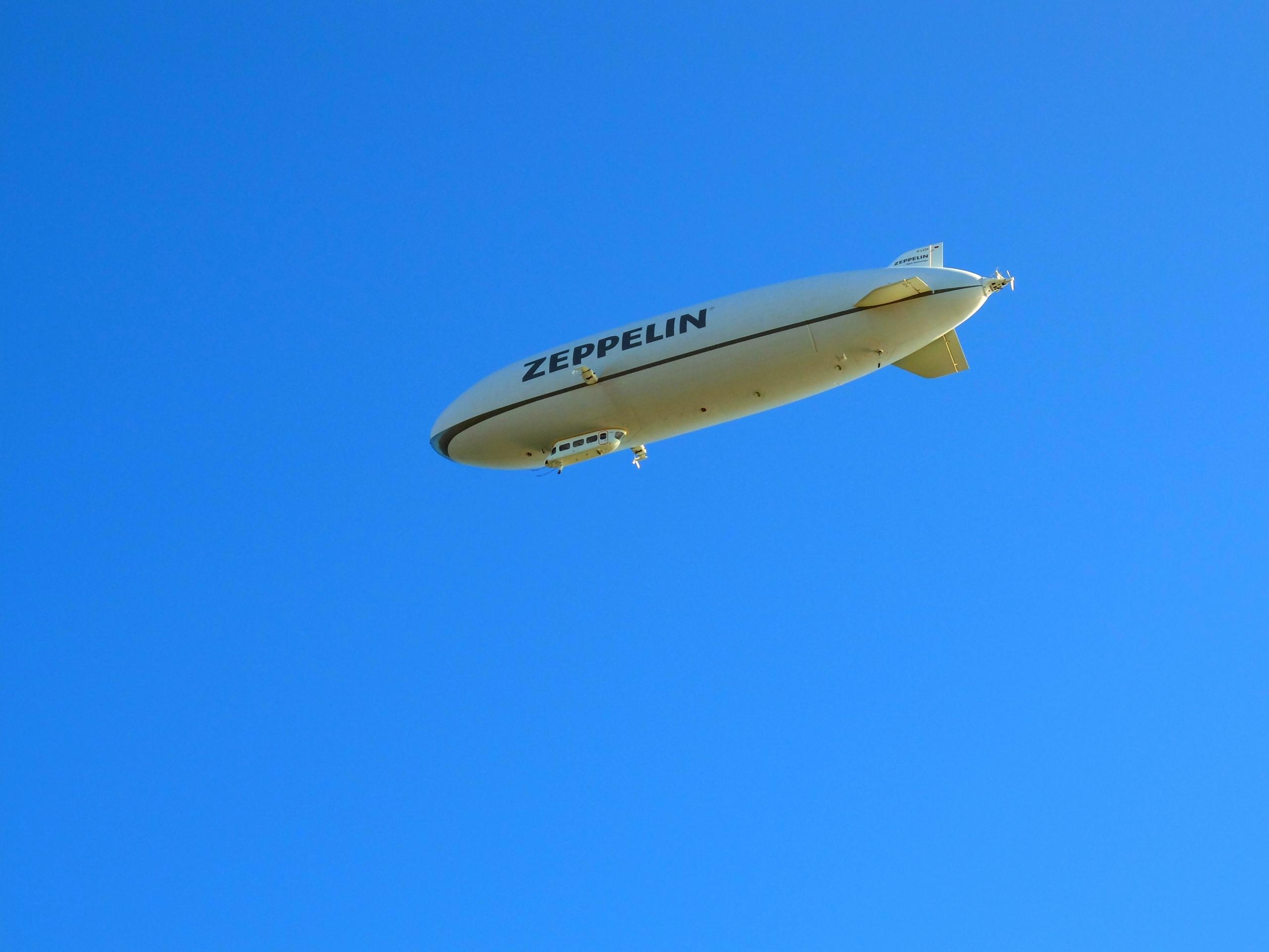 et luftskip flyr under en blå himmel, den har navnet på fartøytypen skrevet på tysk på skroget