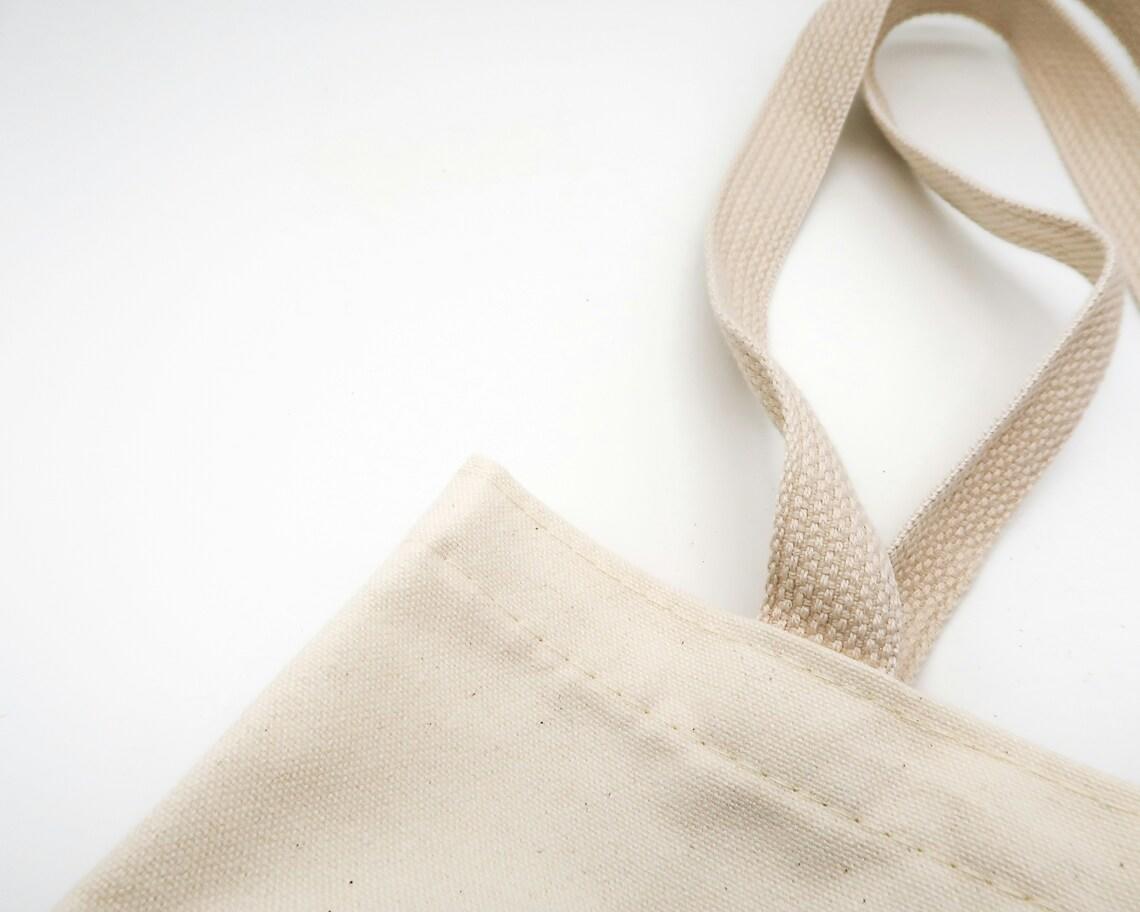 Enkel totebag i hvitt stoff og veske med hank