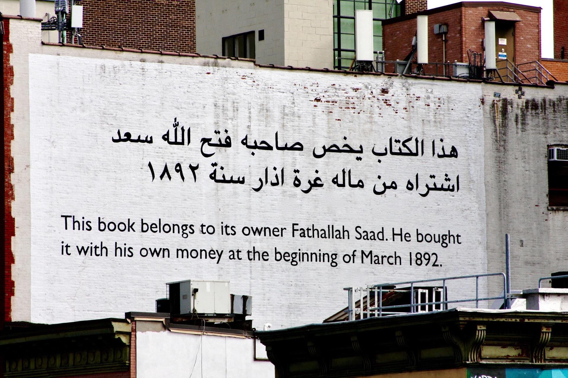 Arabisk og engelsk tekst skrevet på en murvegg