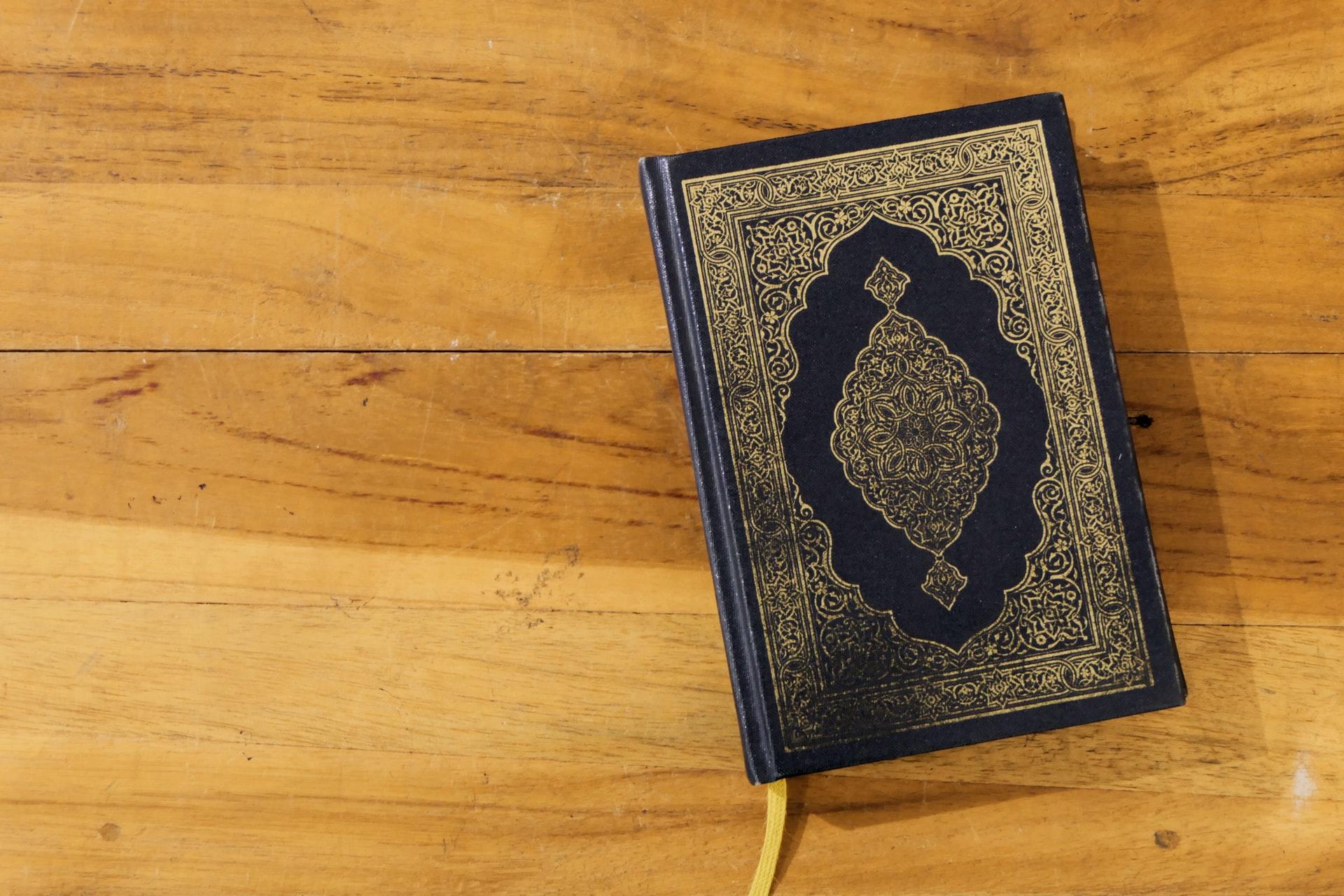 En Koran liggende på et tregulv