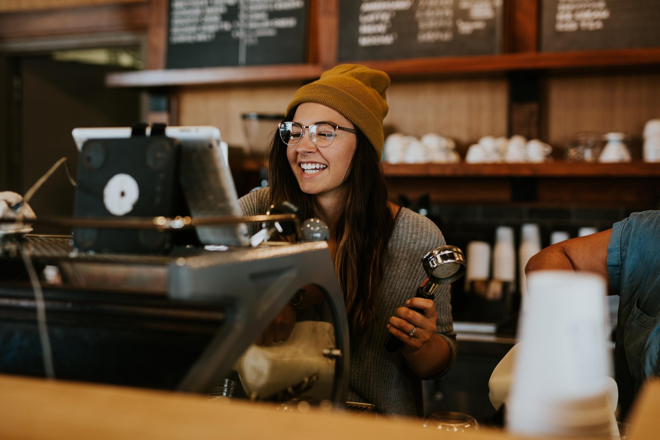 en spansk barista smiler bak disken og spør på spansk hva gjesten vil ha