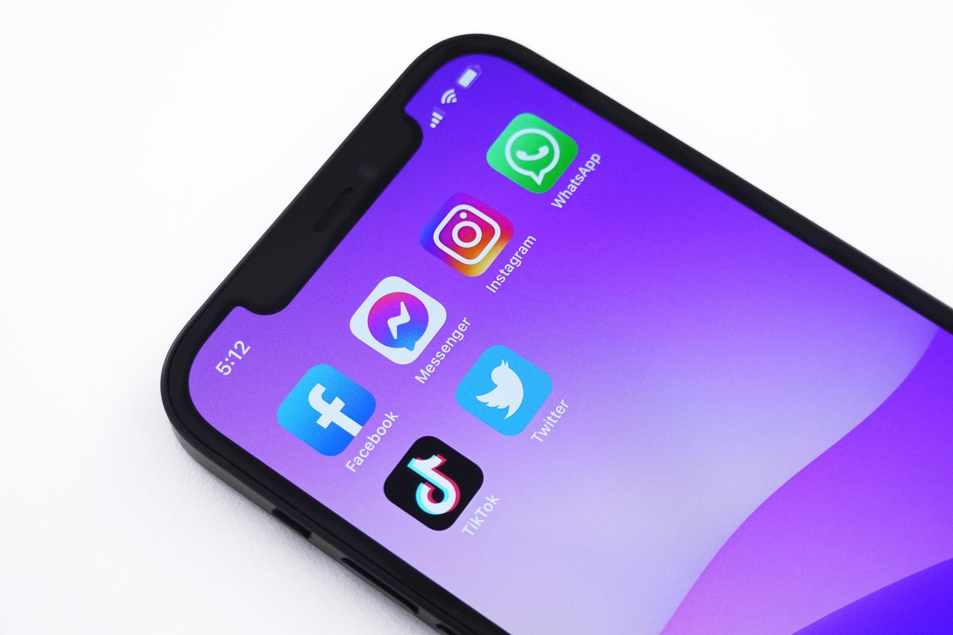 Nærbilde av en iphone som viser apper av sosiale medier som facebook, Messenger, Instagram, TikTok, WhatsApp og Twitter.