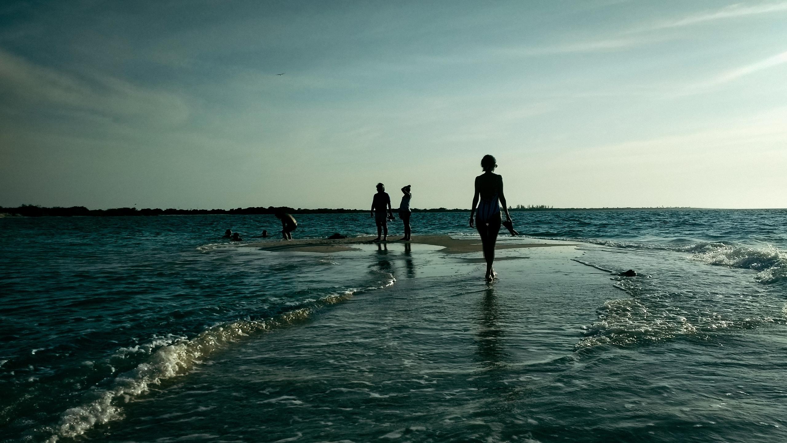 silhuetter av mennesker på en strand, de tar en badepause etter en lang dag med spanskkurs