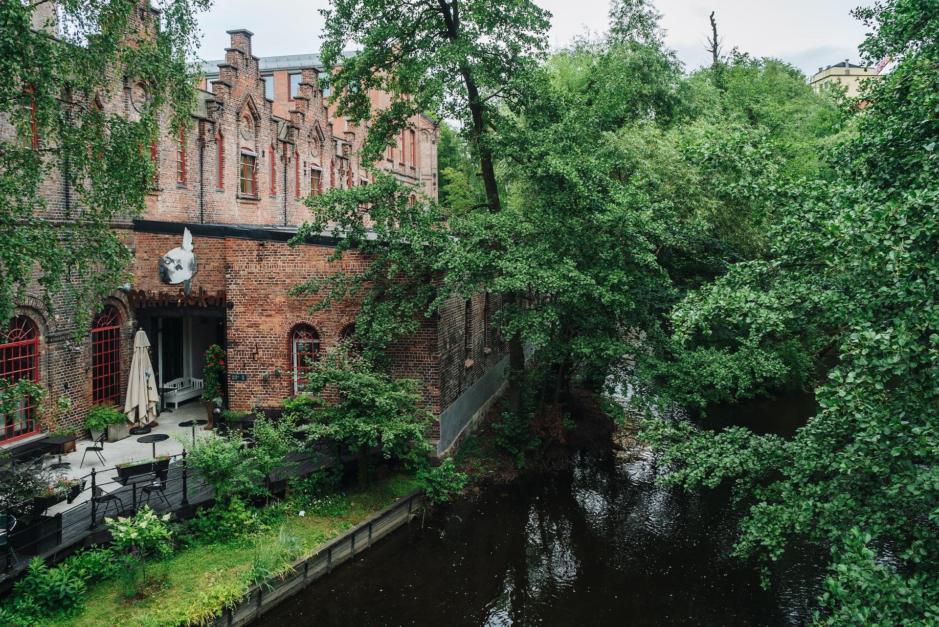 Fabrikkbygg i mur som ligger gjemt mellom trærne ved Akerselva i Oslo.