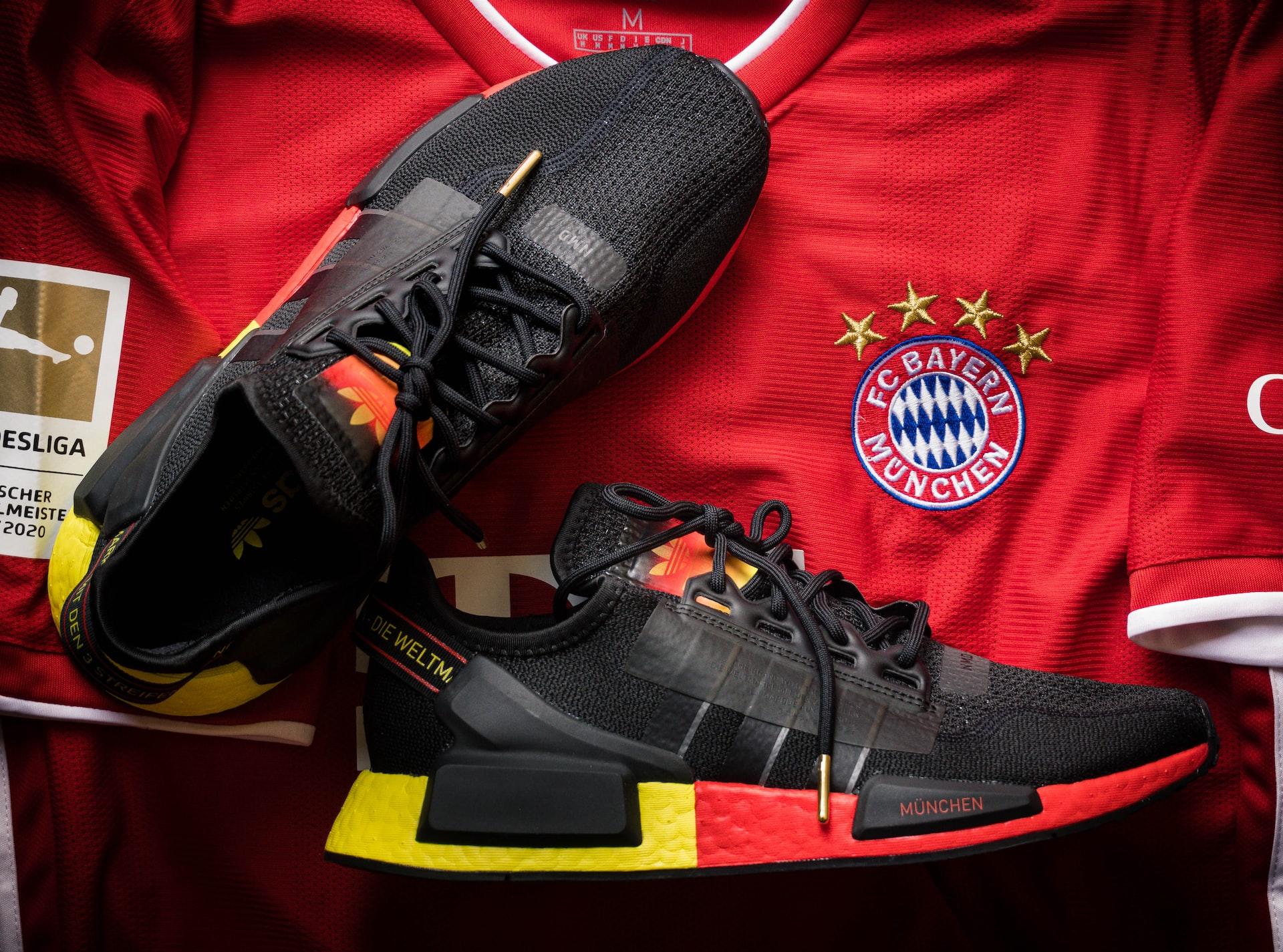 Et par svarte joggesko ligger oppå en Bayern München drakt.