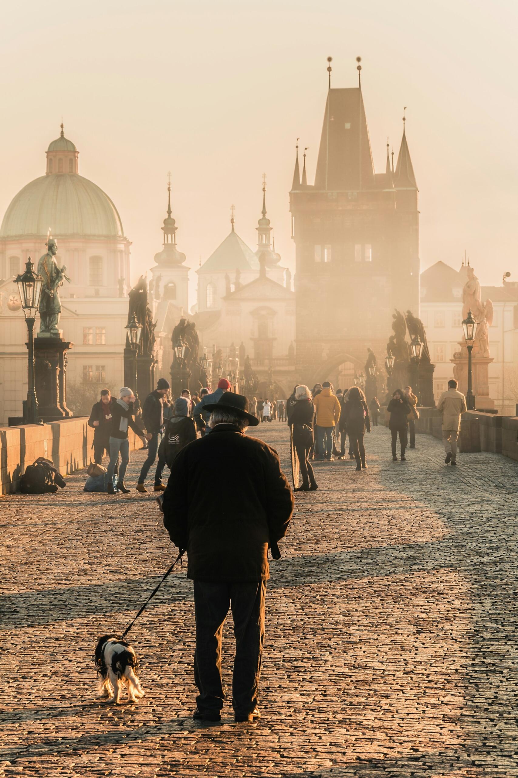 Folkeliv på Karlsbroen i Praha i varmt morgenlys