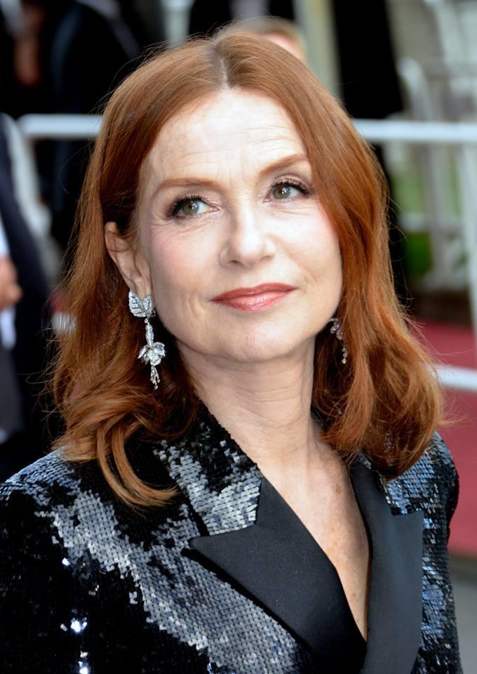 Isabelle Huppert med rødt hår og sort overdel med paljetter.