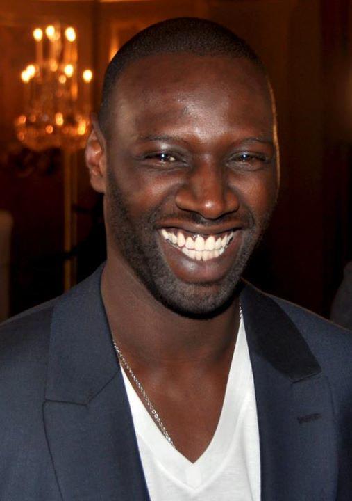 OMar Sy som smiler til kameraet.