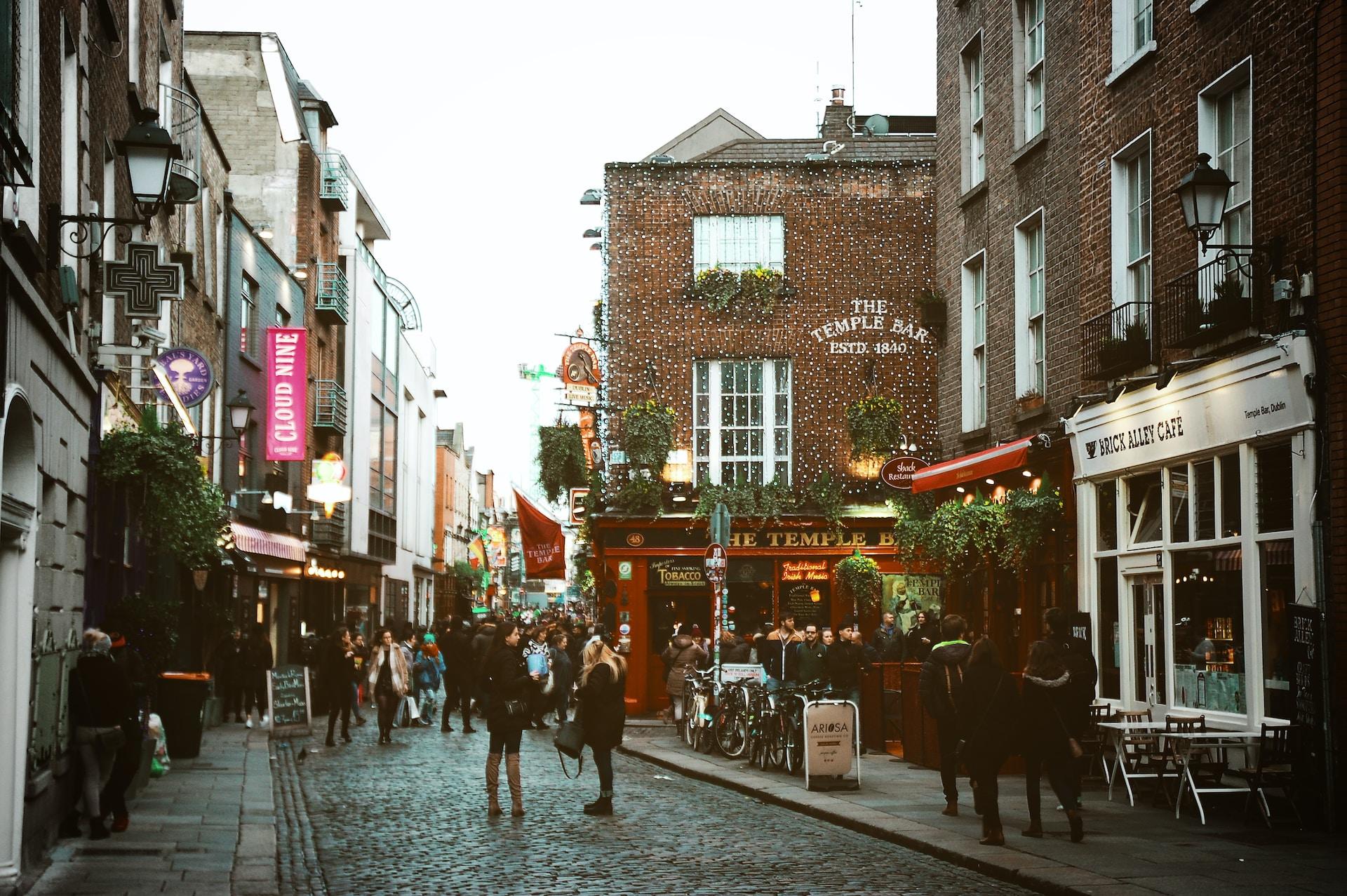 Yrende liv i en gate i Dublin med Temple Bar til høyre.