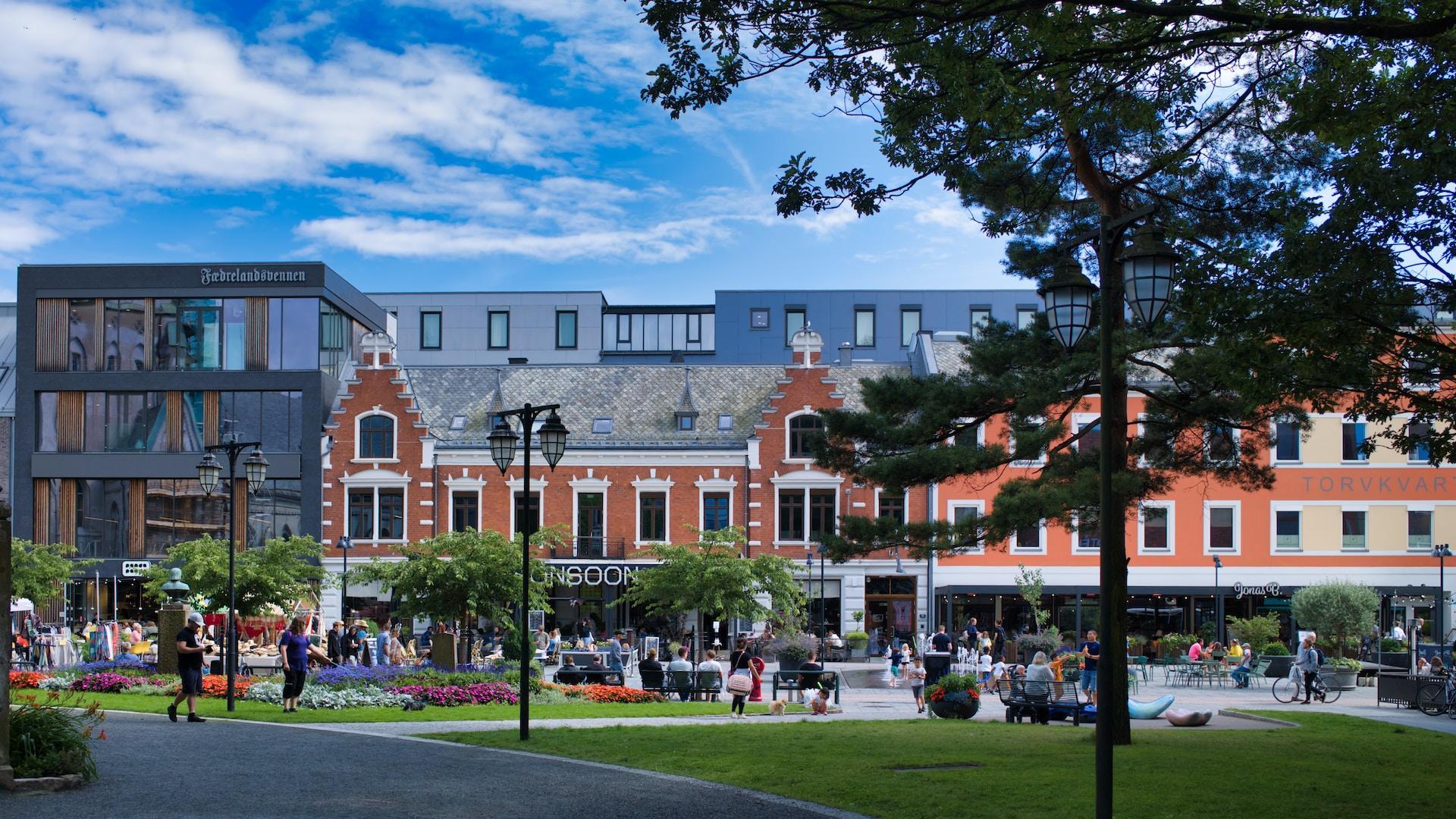 Bilde av byggene og parken på torget i Kristiansand sentrum.