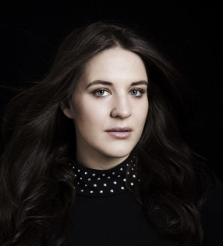 Profilbilde av operasangerinne Lise Davidson på mørk bakgrunn.