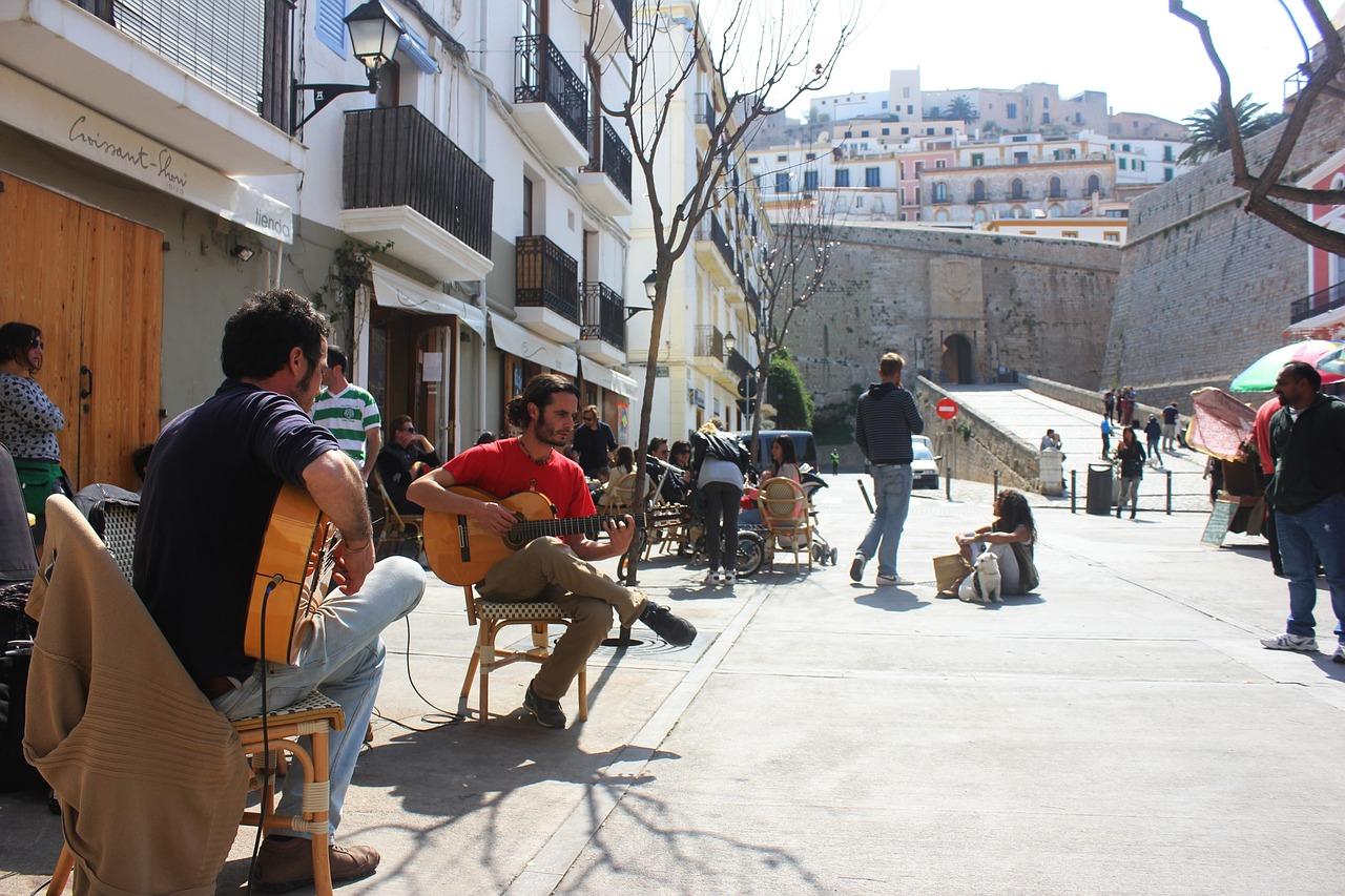 Flamencogitarister fordyper seg i kunsten på en livlig gate i Spania, omgitt av den urbane sjarmen til Andalusia.