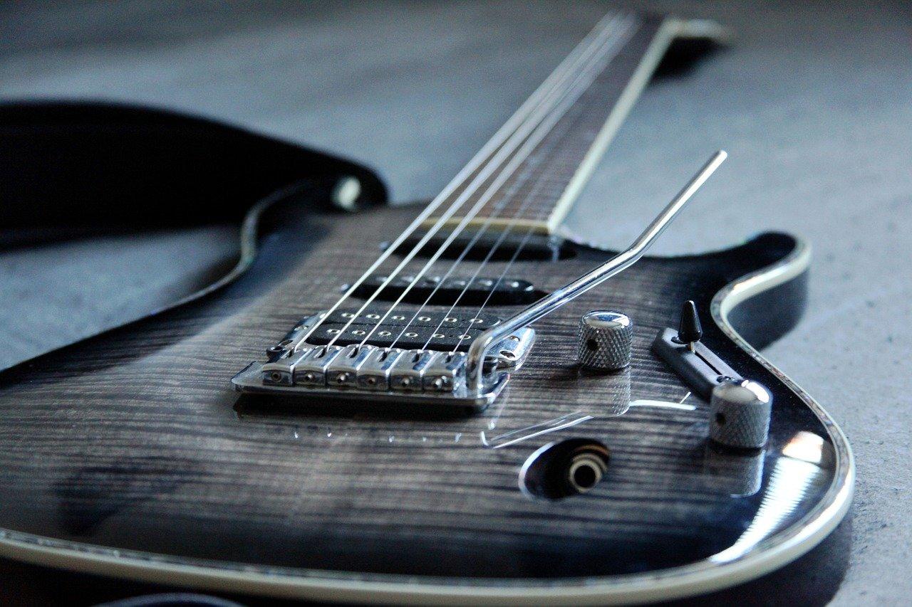 Sort el-gitar ligger på et bord klar til bruk