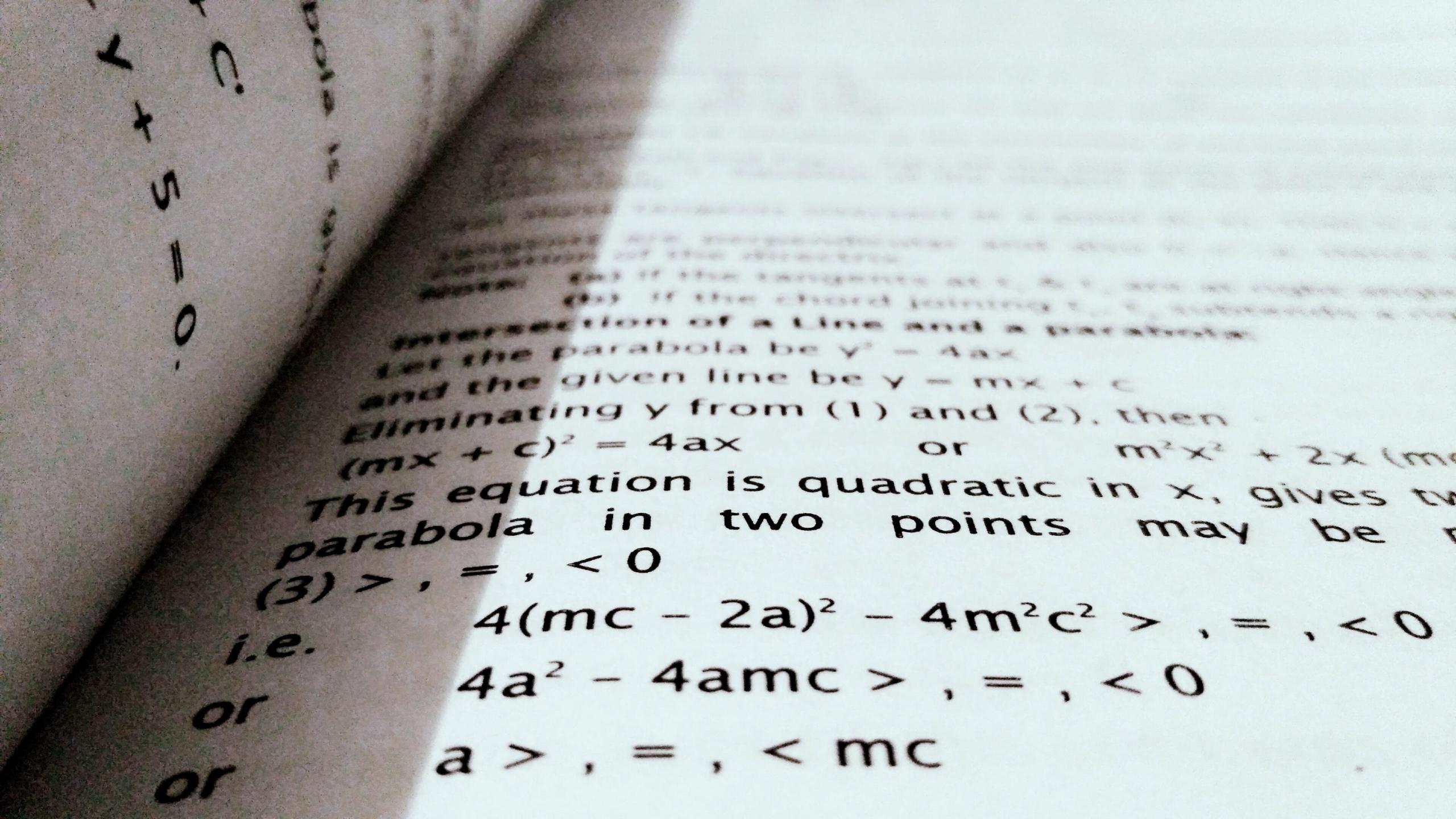 Nærbilde av en mattebok med fokus på komplekse algebraiske ligninger og teorier.