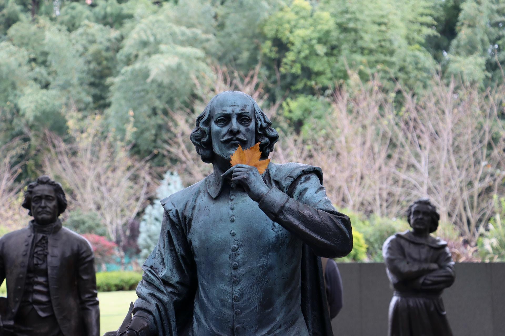 Statue av Shakespeare som holder en høstfarget lønneblad.