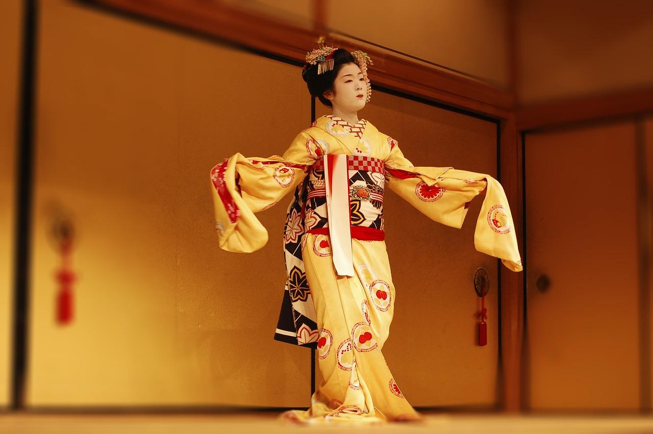 En geisha fremfører en tradisjonell japansk dans i en utsmykket kimono.