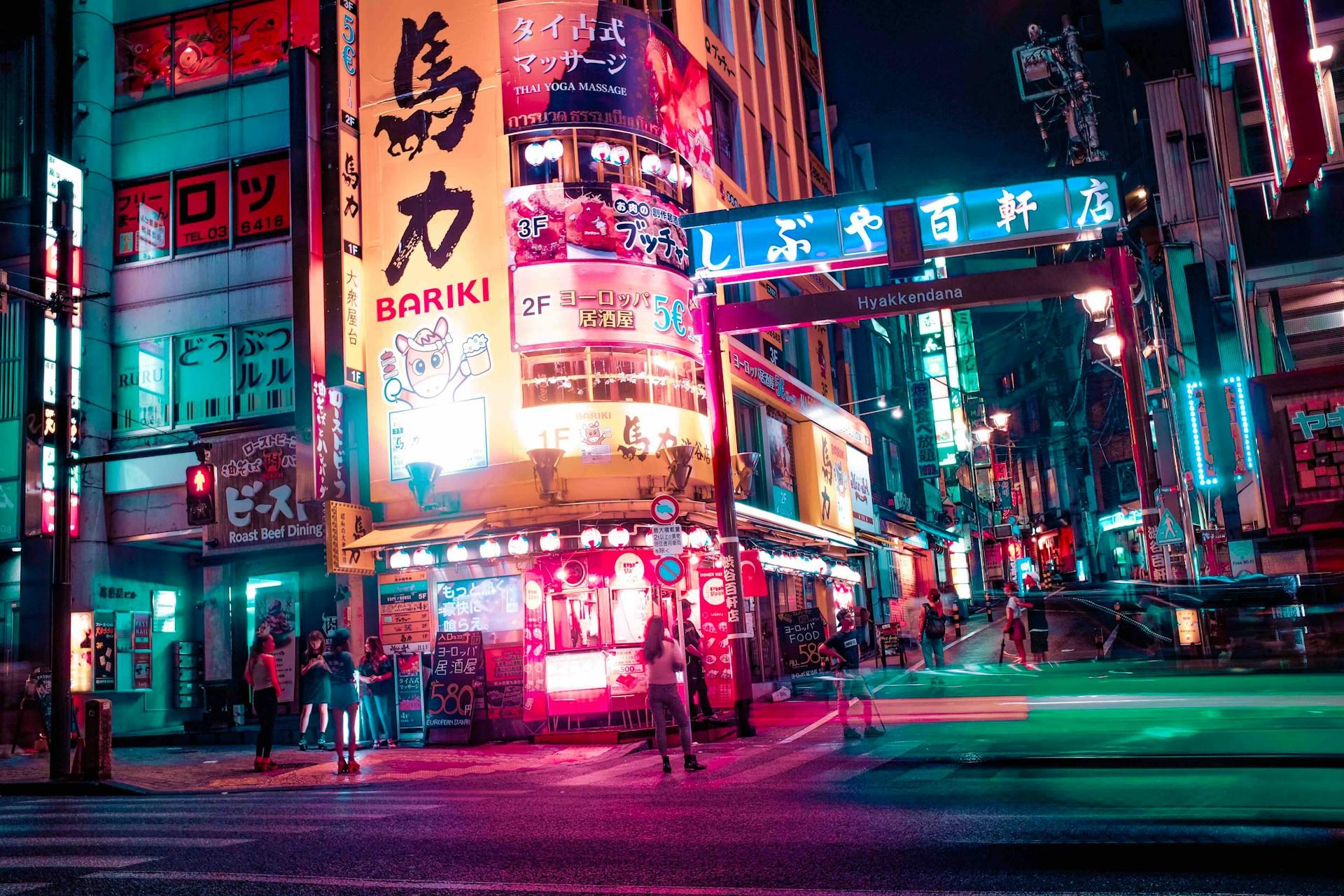 Japansk by om kvelder med store skilt og neonlys.
