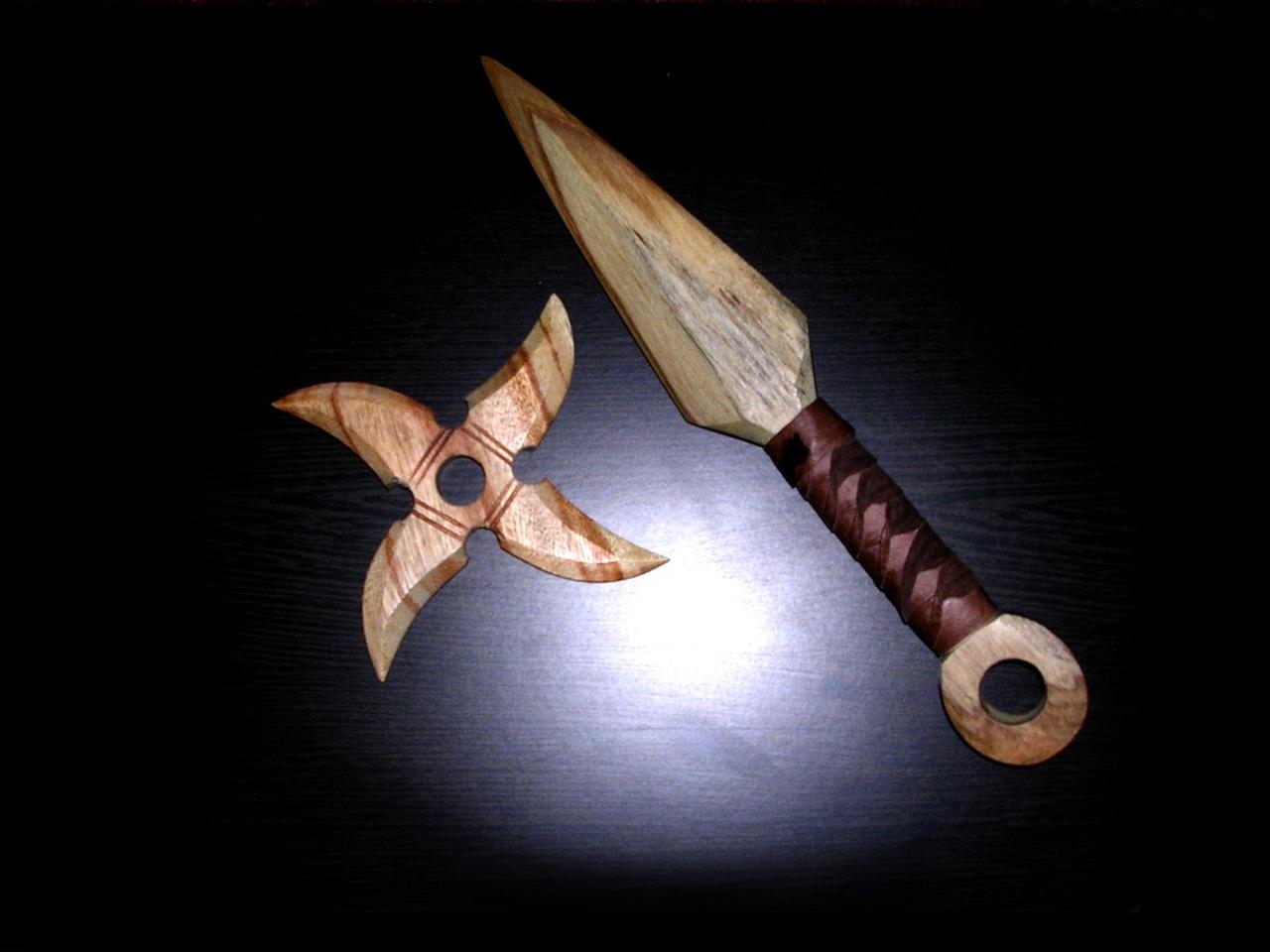 En tre-shuriken og en tre-kunai plassert på en mørk bakgrunn, representasjoner av ninja kastevåpen.