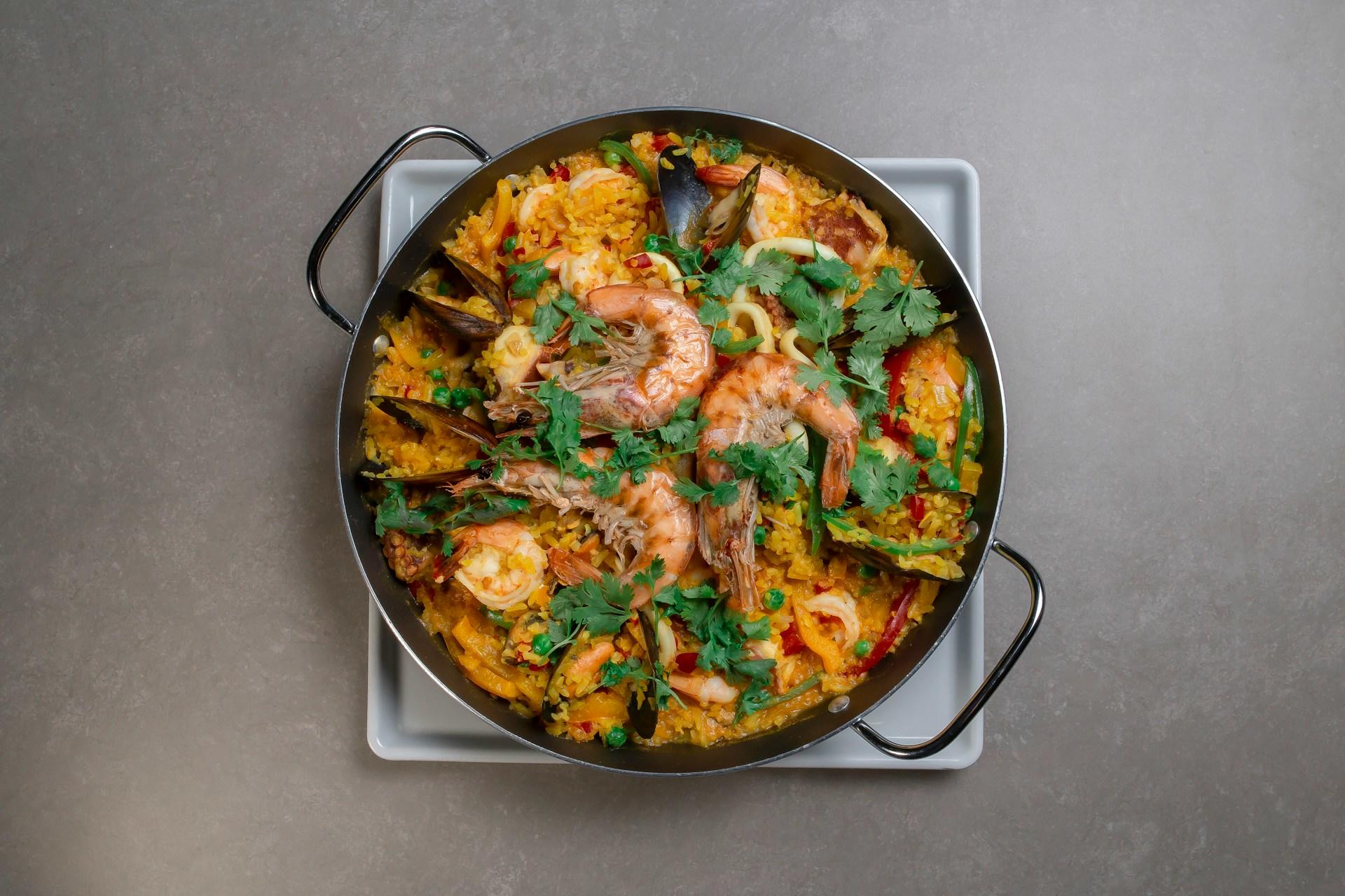 Panne med paella på en hvit tallerken.