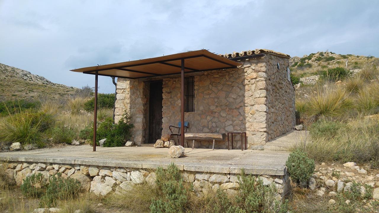 En rustikk steinhytte i det mallorkinske fjellandskapet langs turstien på GR221