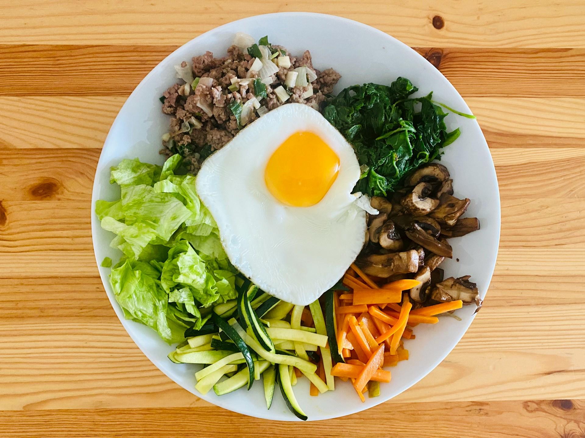 Hvit skål med den koreanske retten bibimbap.