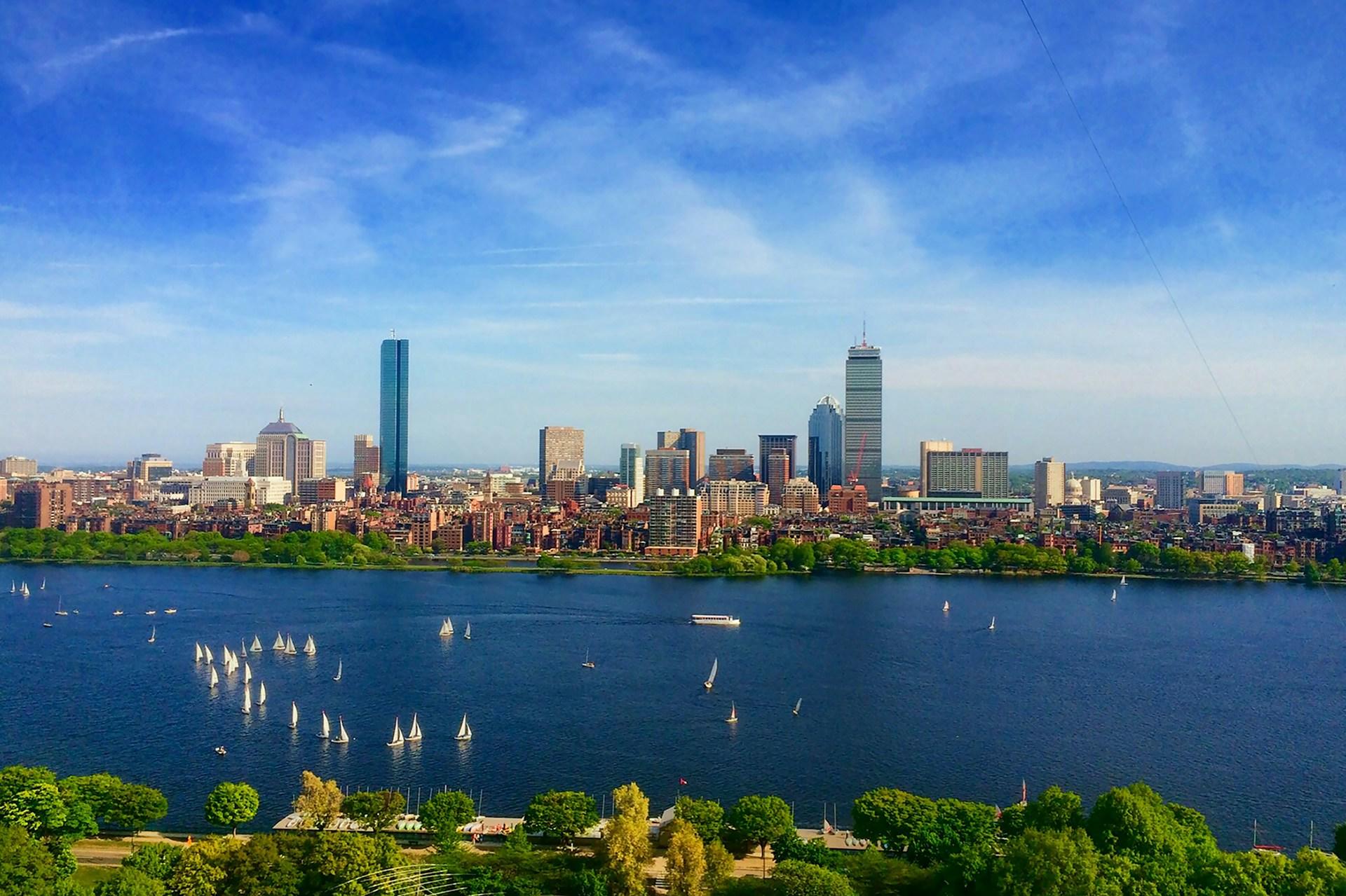 Bilde av Boston fra vannkanten med blå himmel. 