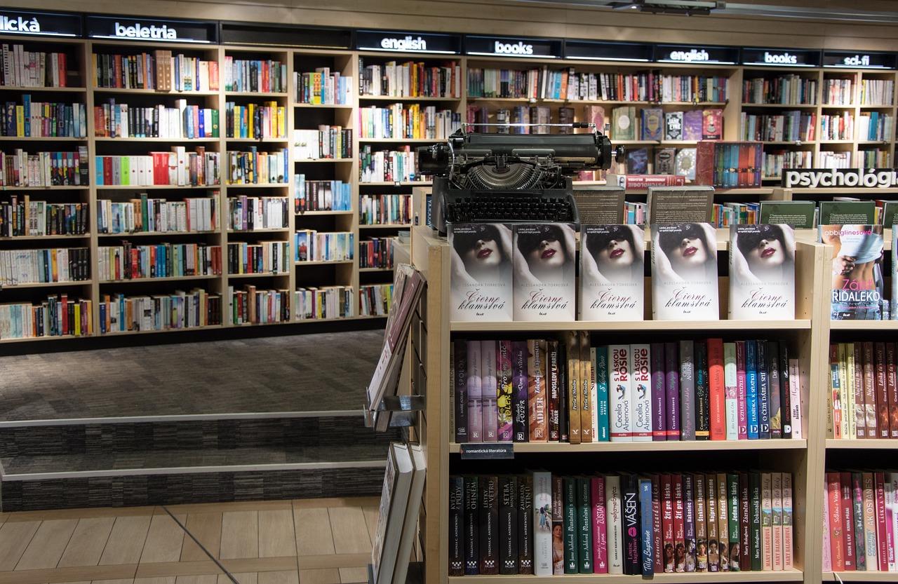 Bokhyller i et bibliotek med en rekke utgitte bøker og en gammeldags skrivemaskin.