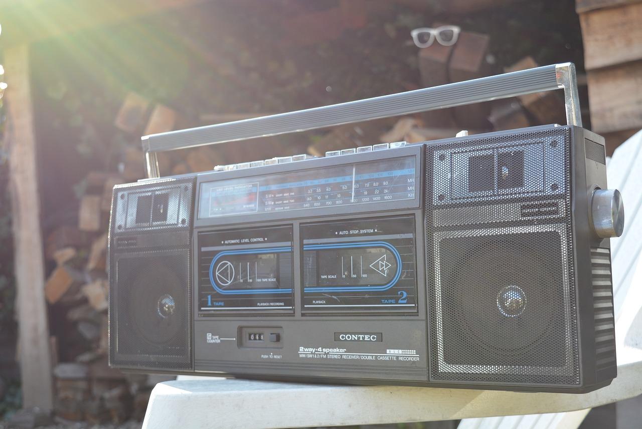 En gammeldags boombox med kassettspiller står i sollyset.
