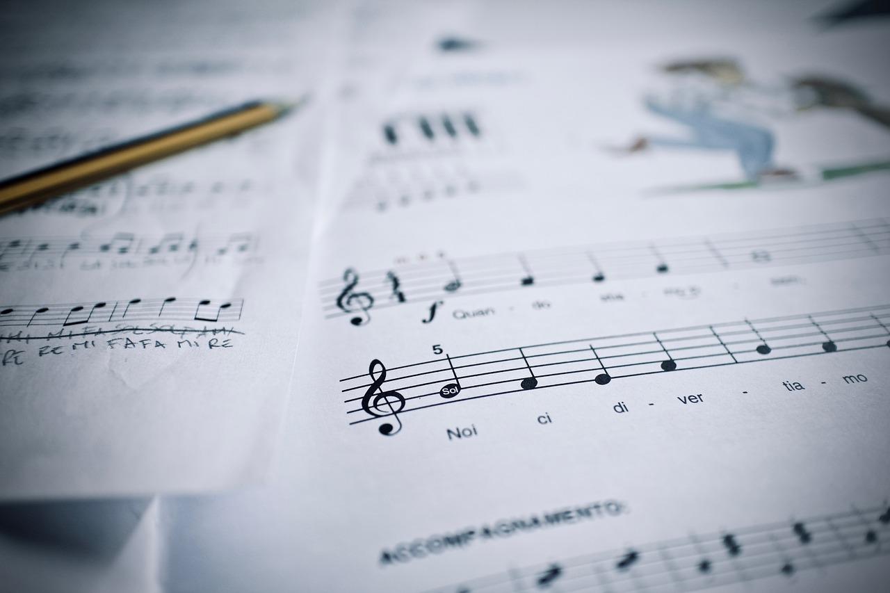Et noteark med håndskrevne noter og tekst, musikalsk komposisjon i utvikling.