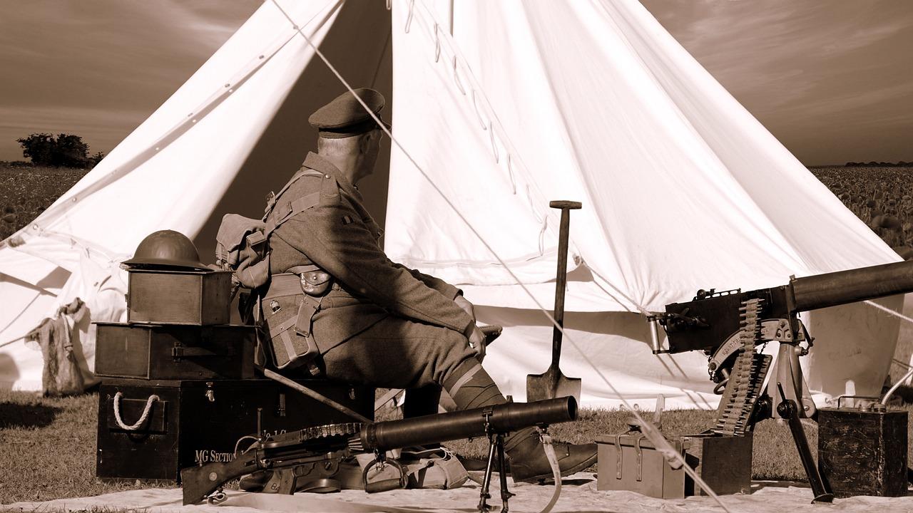 Soldat sitter ved et telt med våpen og utstyr under første verdenskrig.