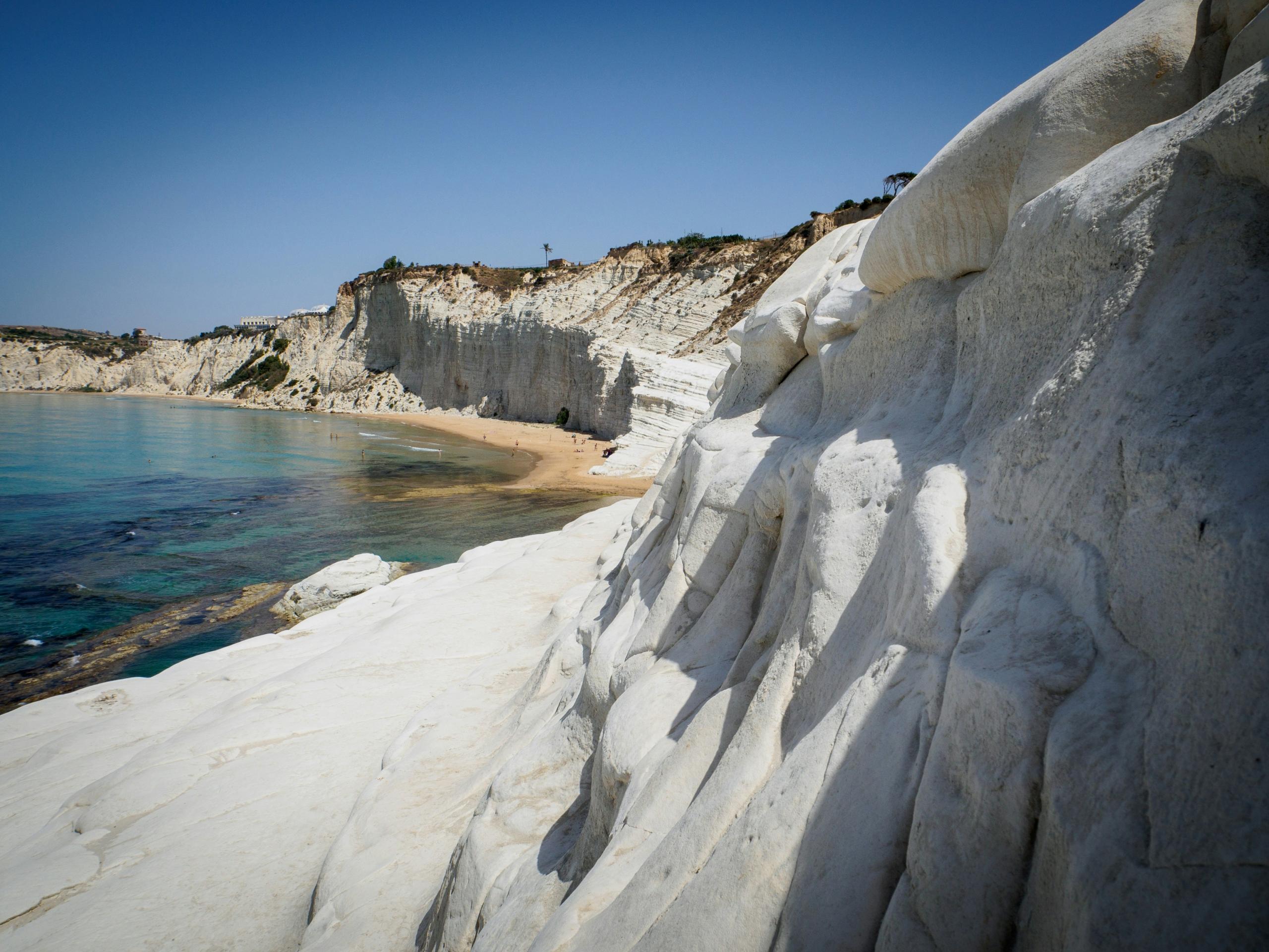 Hvite klipper ved stranden Scala dei Turchi på Sicilia med mennesker som nyter stranden