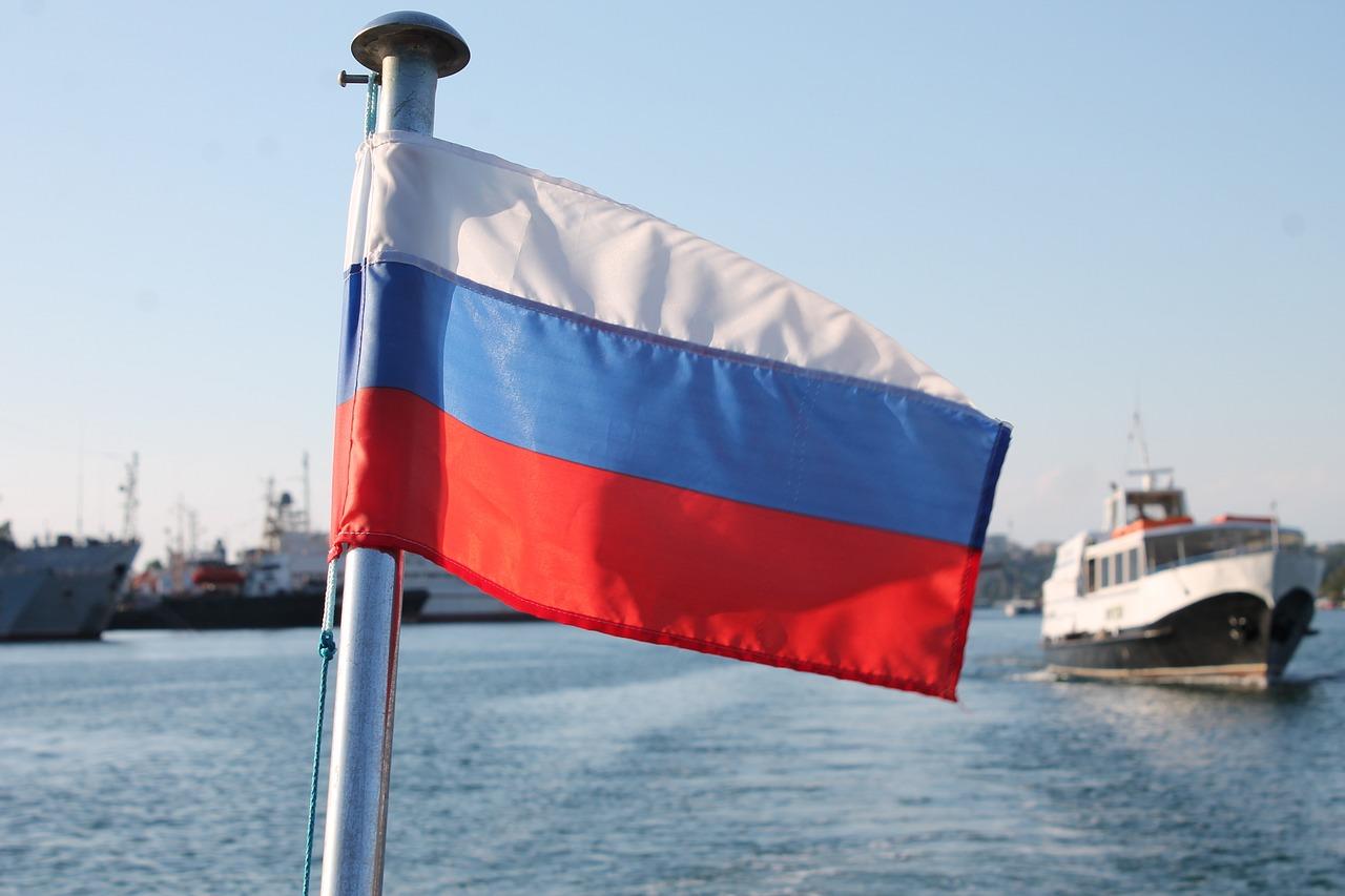 Det russiske flagget vaier på en båt med flere skip i bakgrunnen.