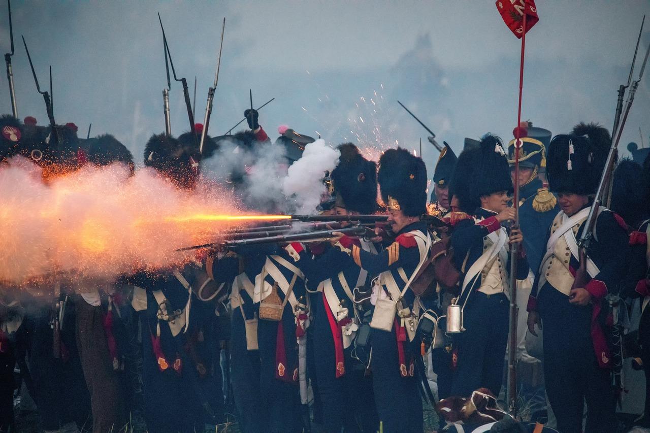 Soldater i uniformer fra Napoleons tid avfyrer musketter under en rekonstruksjon av Slaget ved Waterloo.