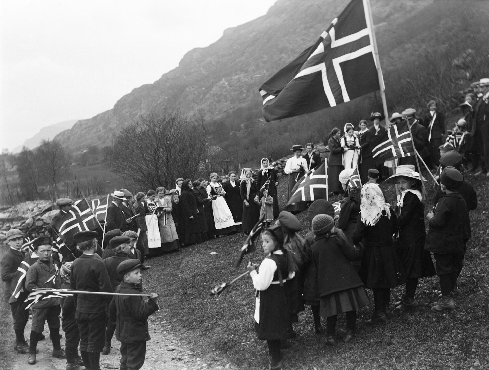 Norske barn og voksne med norske flagg feirer frigjøringen i svart-hvitt-fotografi